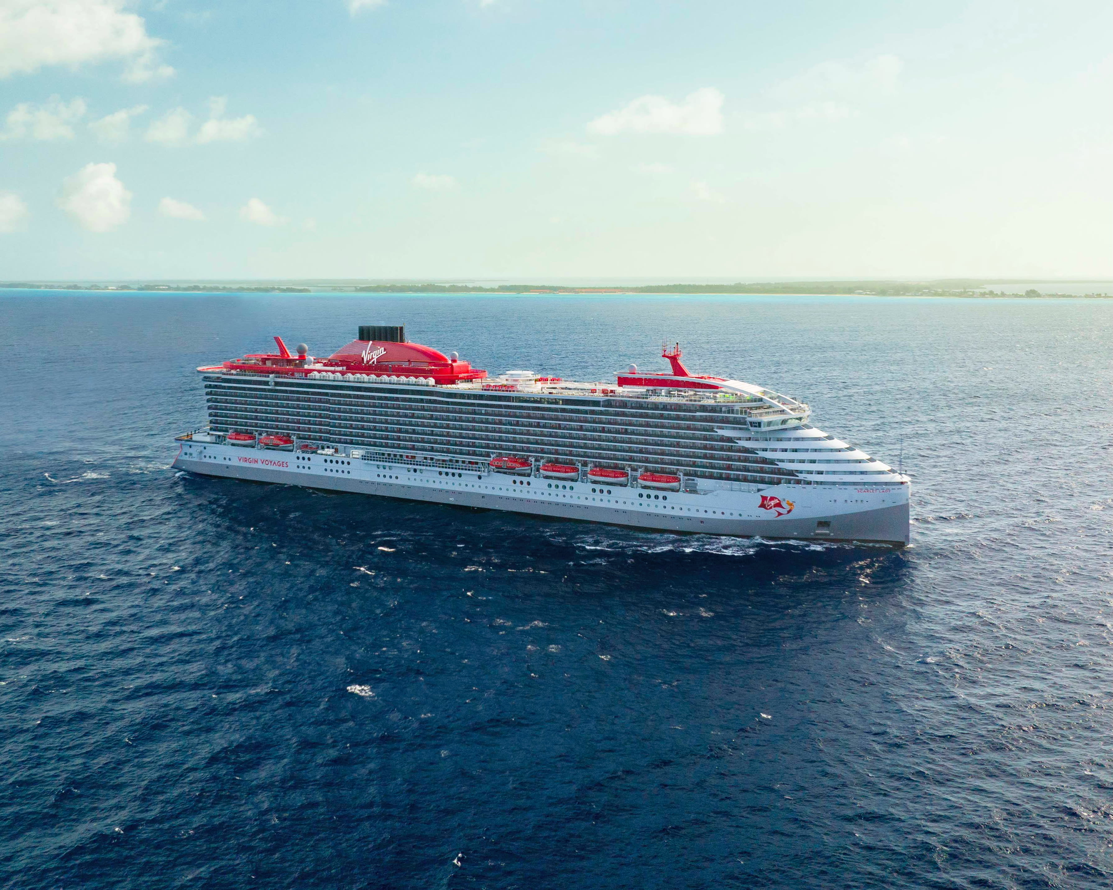 large modern white and red cruise ship at sea during day