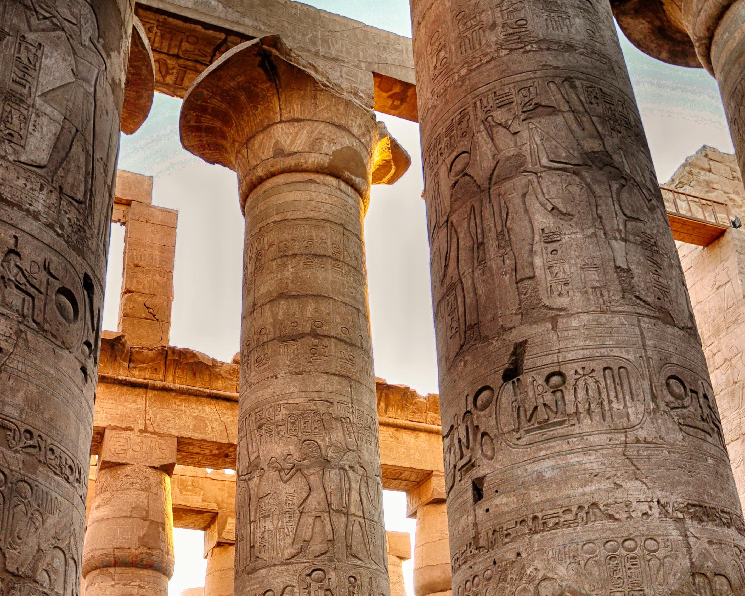 ancient temple columns with hieroglyphs during day 