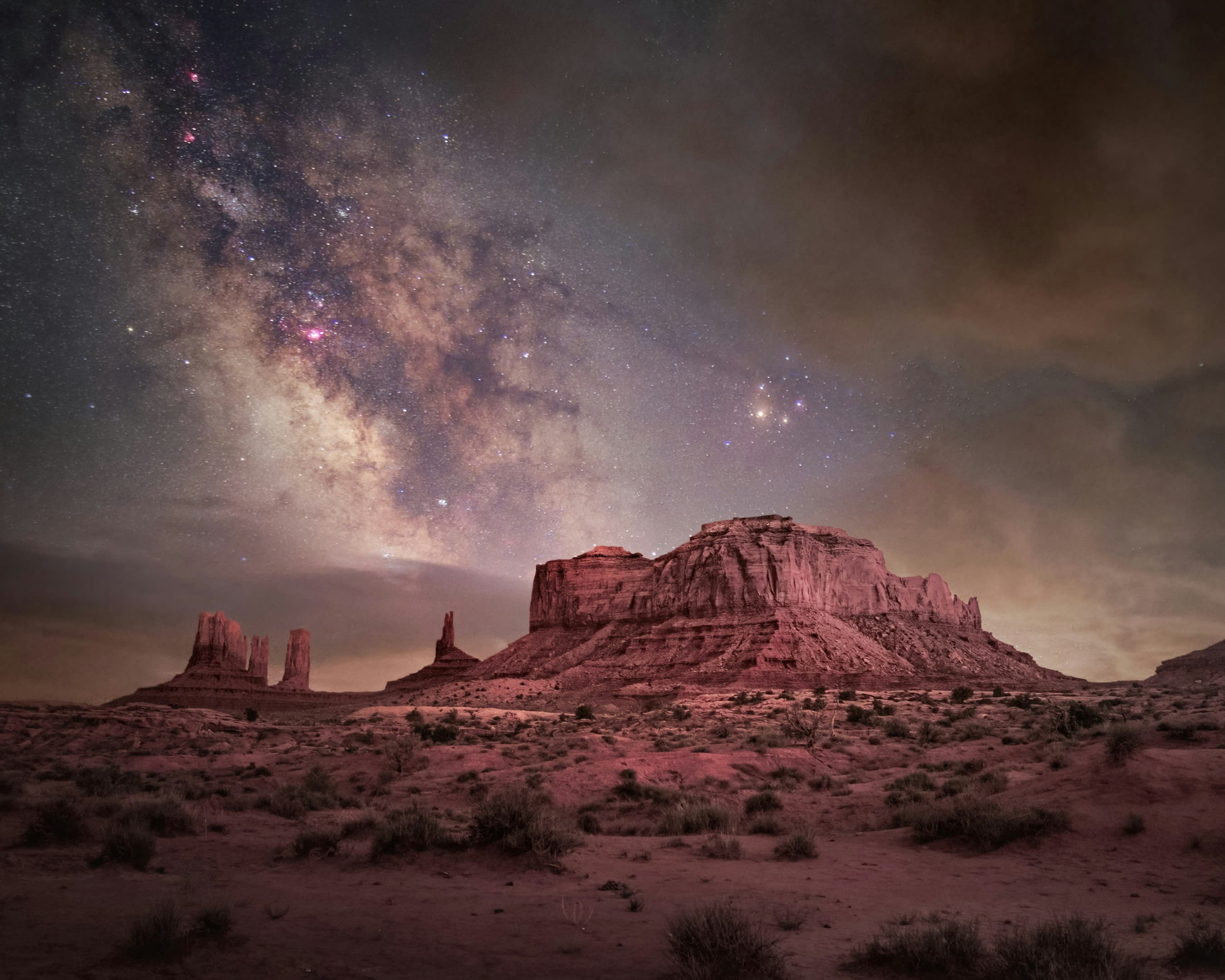 stars and constellations in the sky above a rocky mountain desert landscape at night