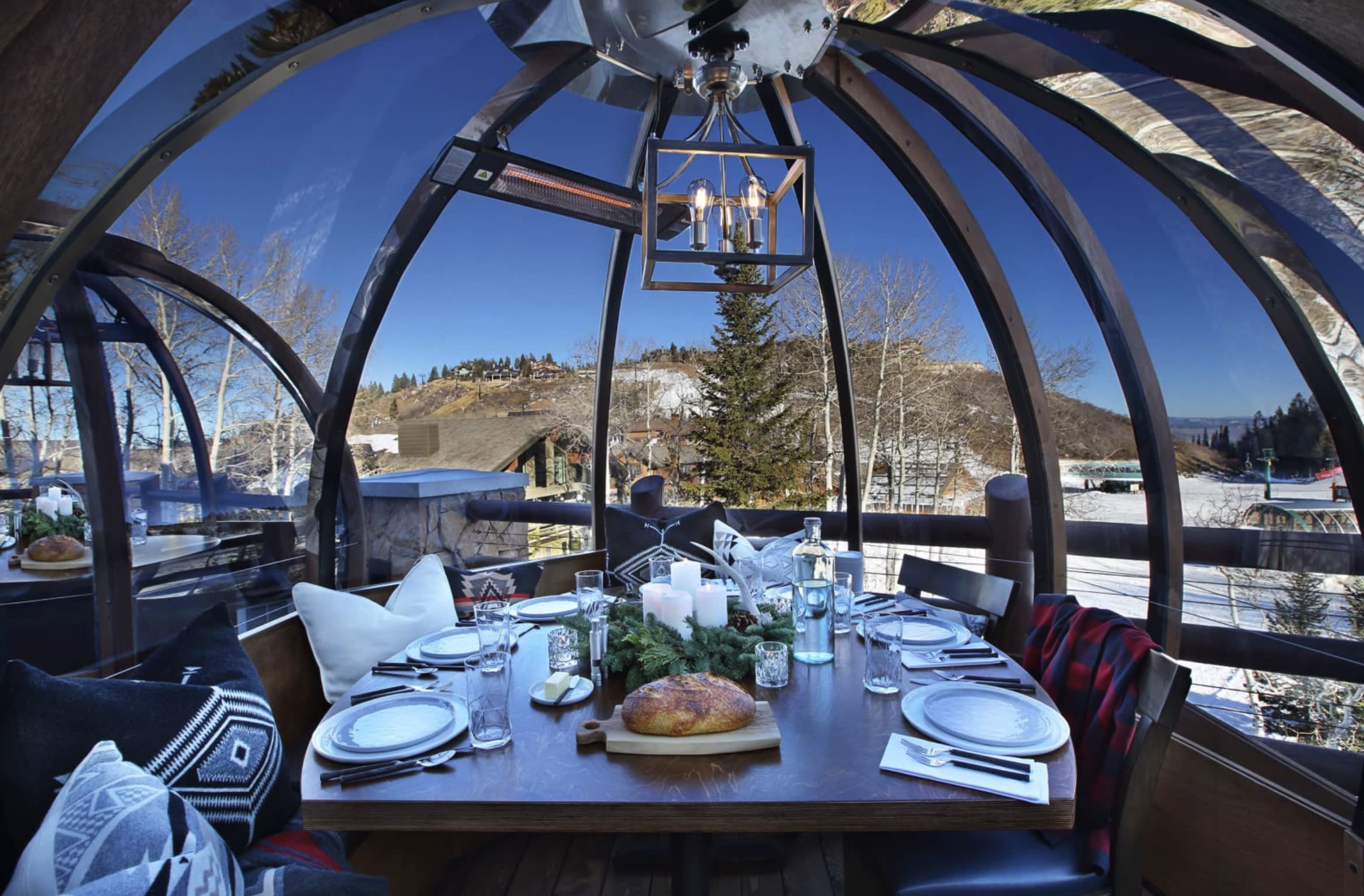 outdoor glass dome with dining table and snowy mountain view