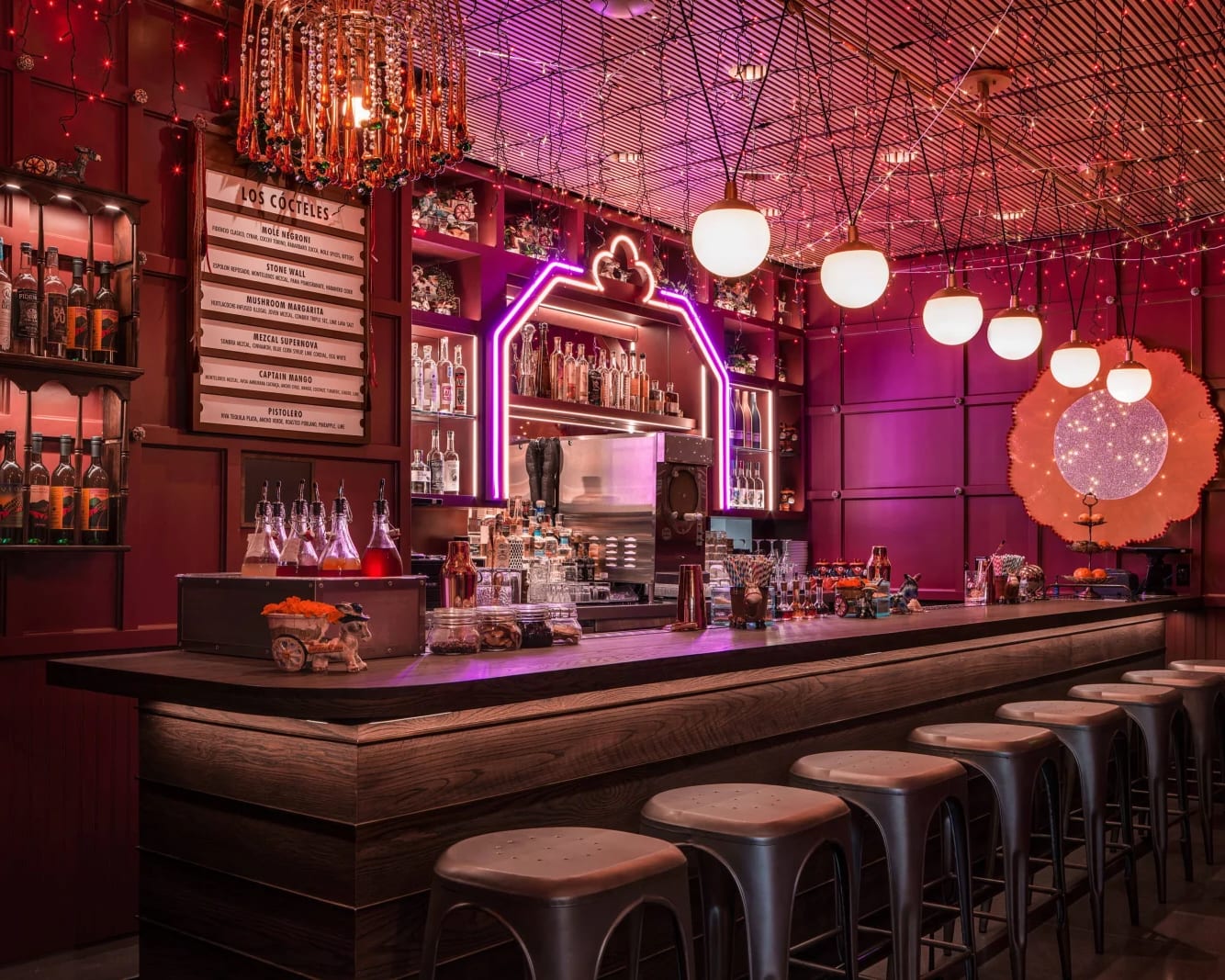 A purple neon bar with metal stools and Mexican decor