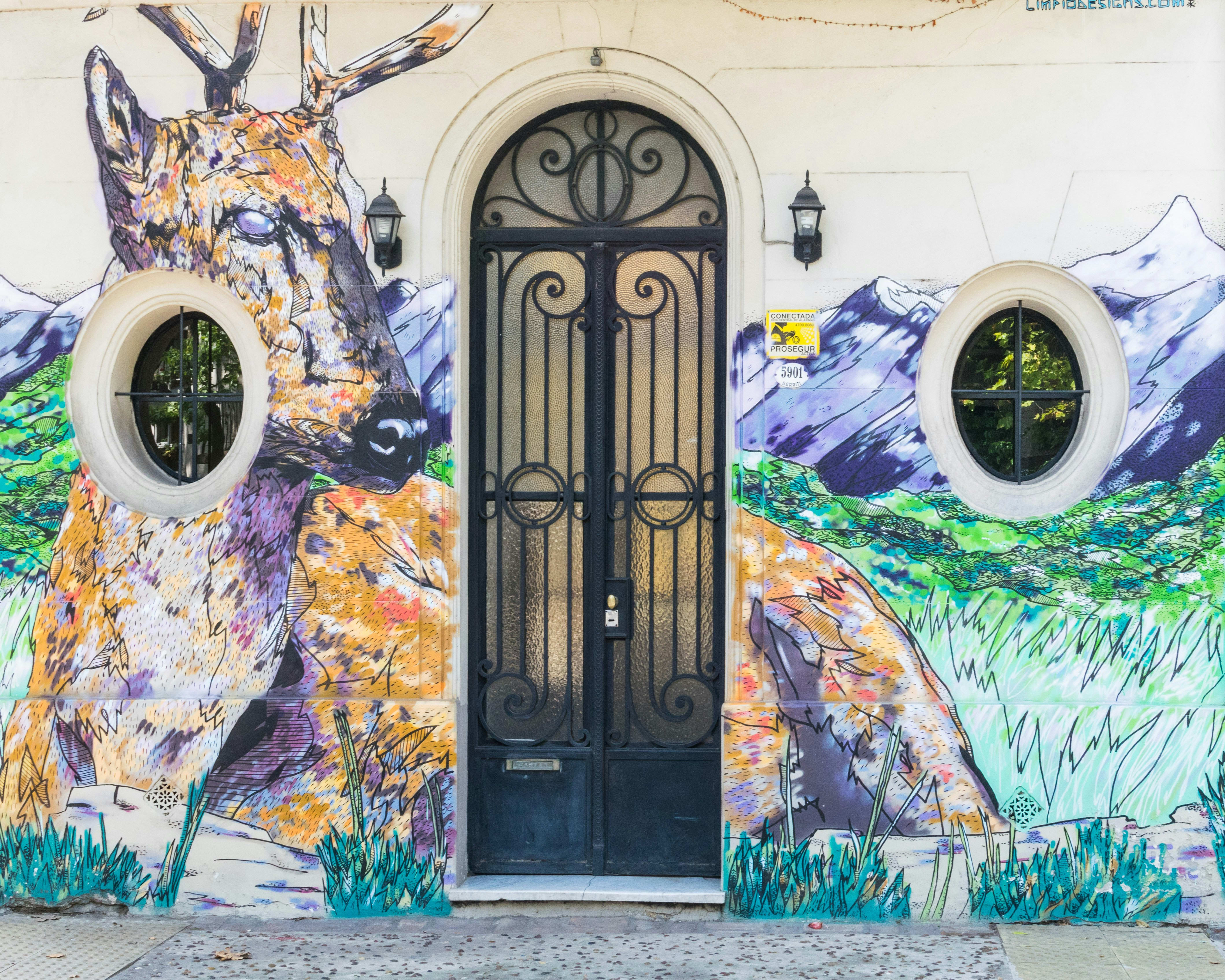 ornate white building and black wrought iron door with vibrant colorful graffiti
