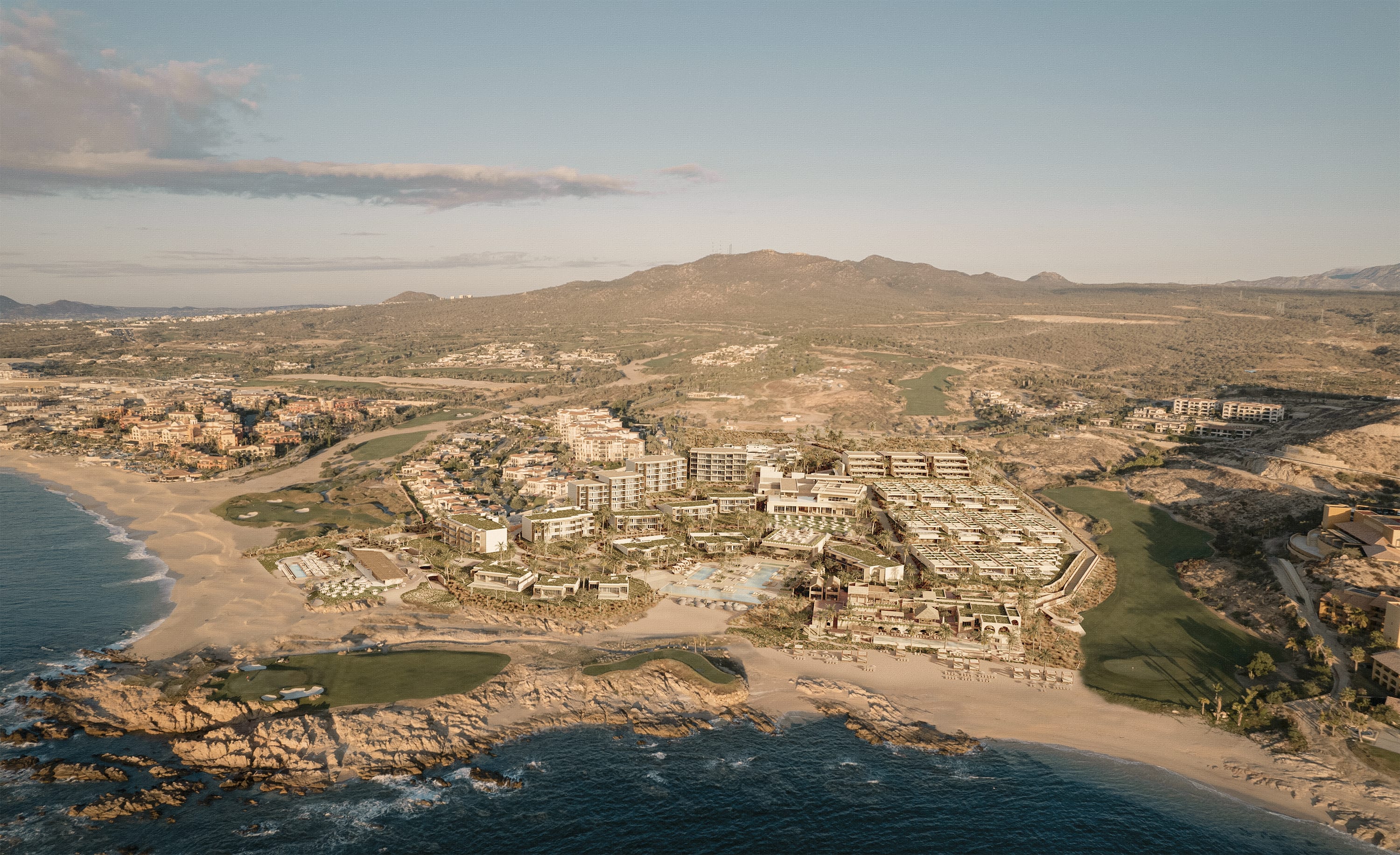 Aerial view of a luxury beachfront resort in Los Cabos, Mexico, surrounded by desert hills, a golf course, and the Pacific Ocean under warm golden light.