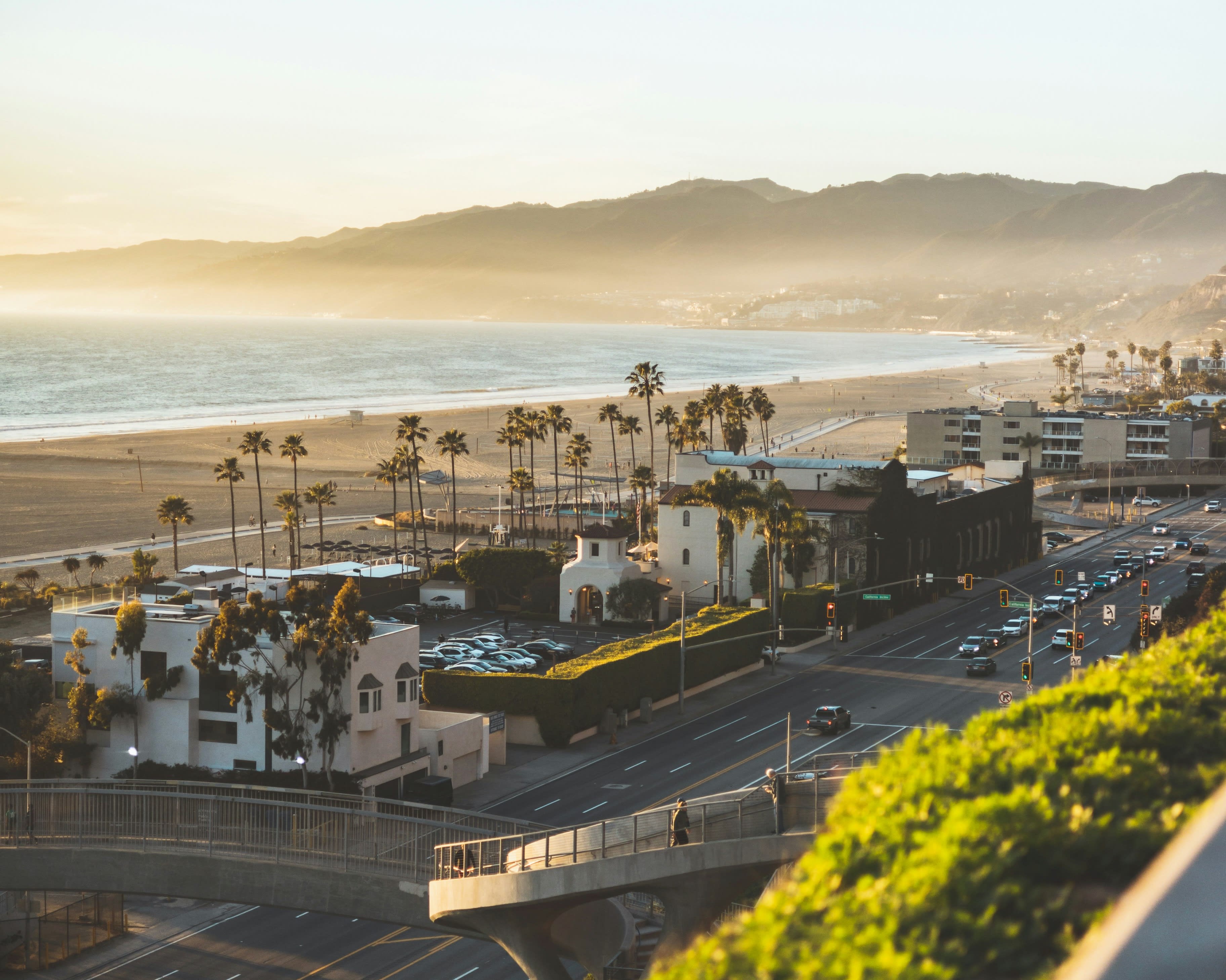 road and houses along a beach with mountains in the background during late afternoon