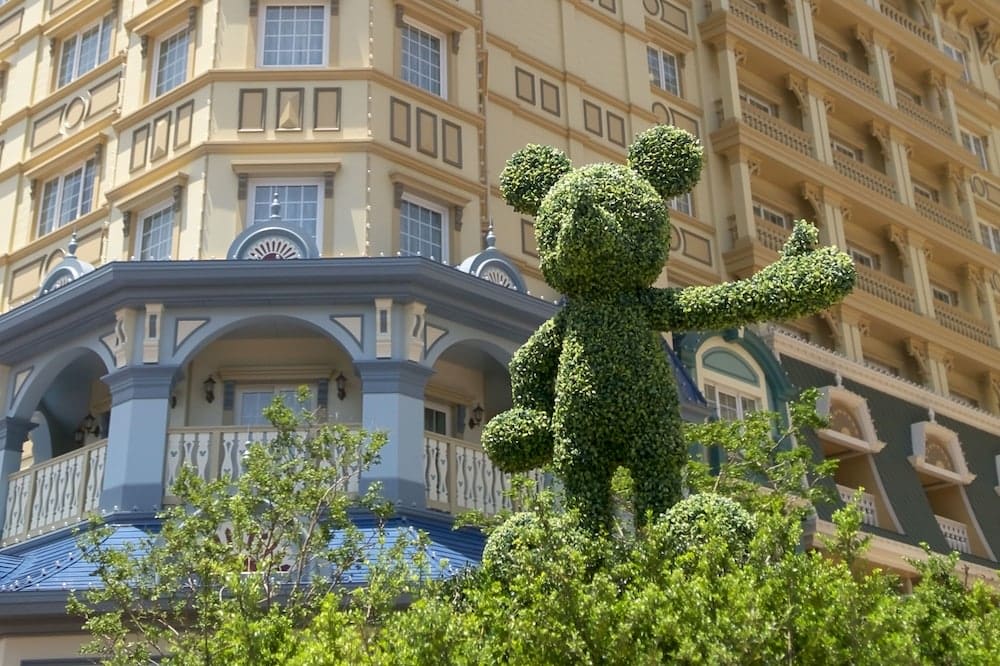 topiary character in front of a blue and white hotel during day