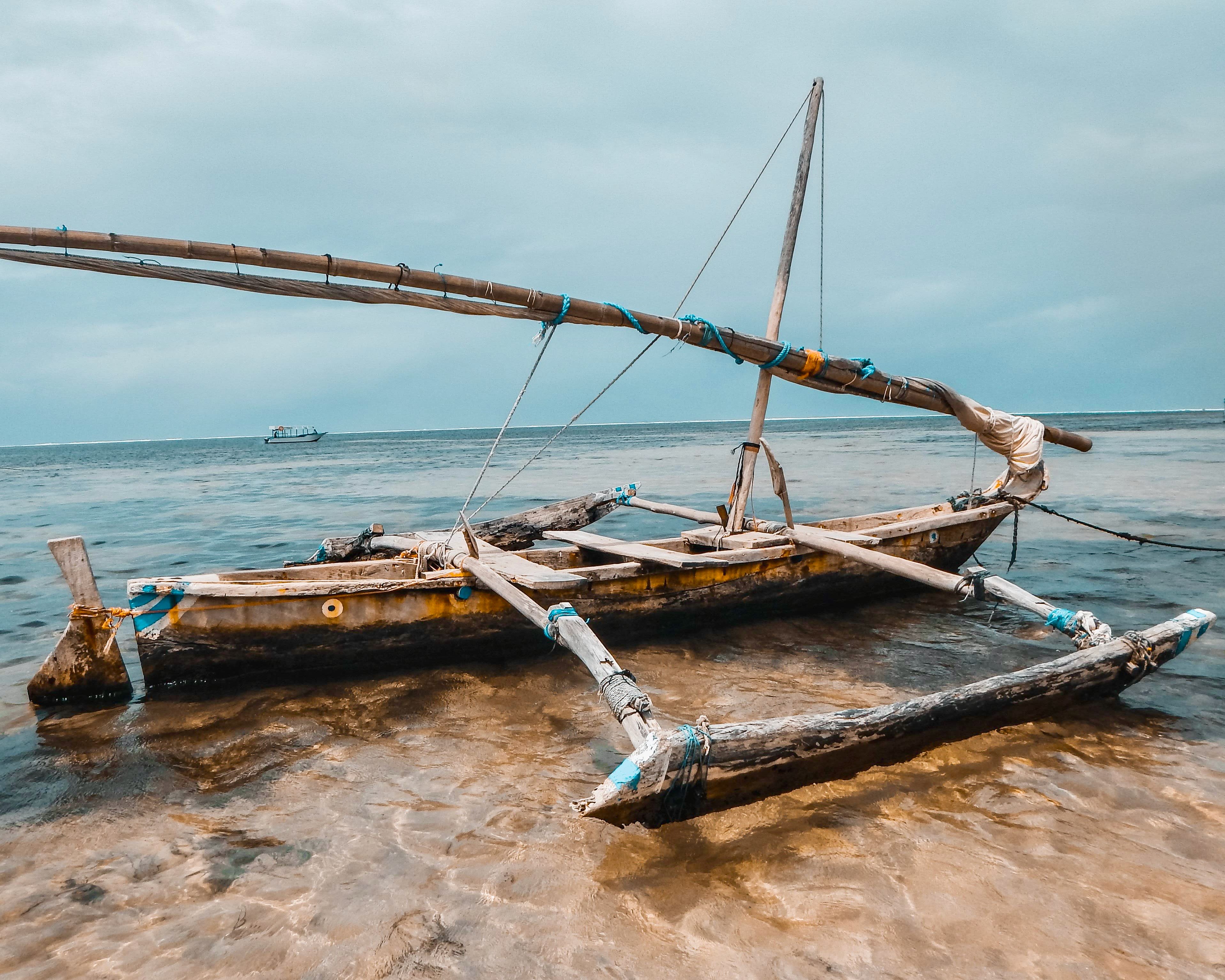 a traditional dhow wood boat in the water