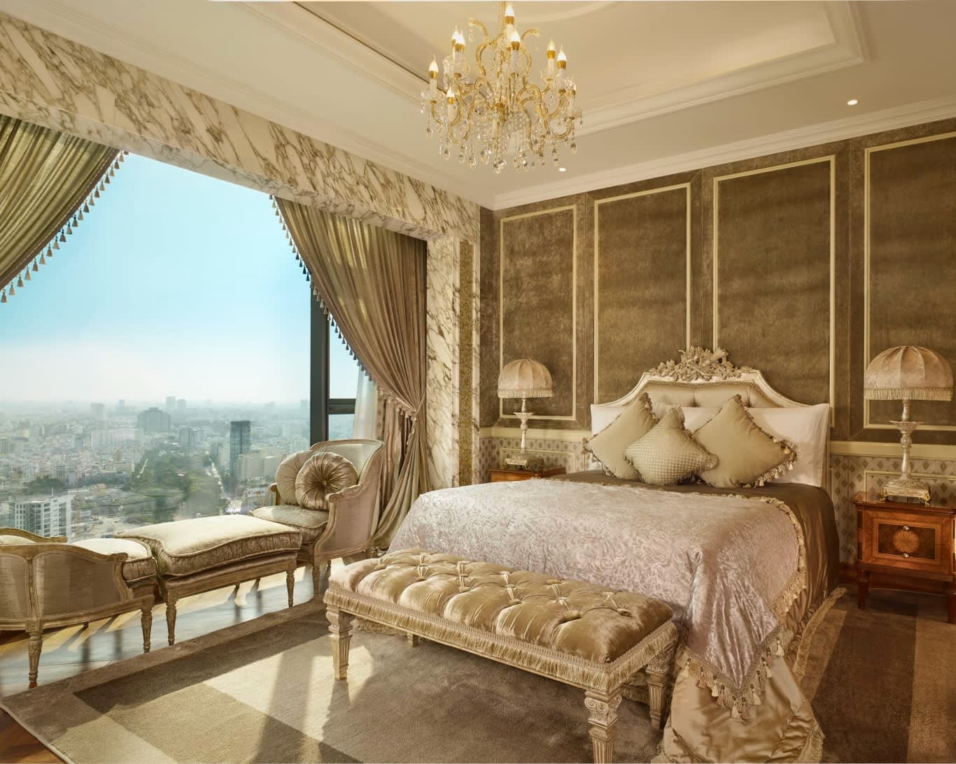 a luxurious, ornate bedroom with light linens, gold accents, and wood furniture with a chandelier and window overlooking a city