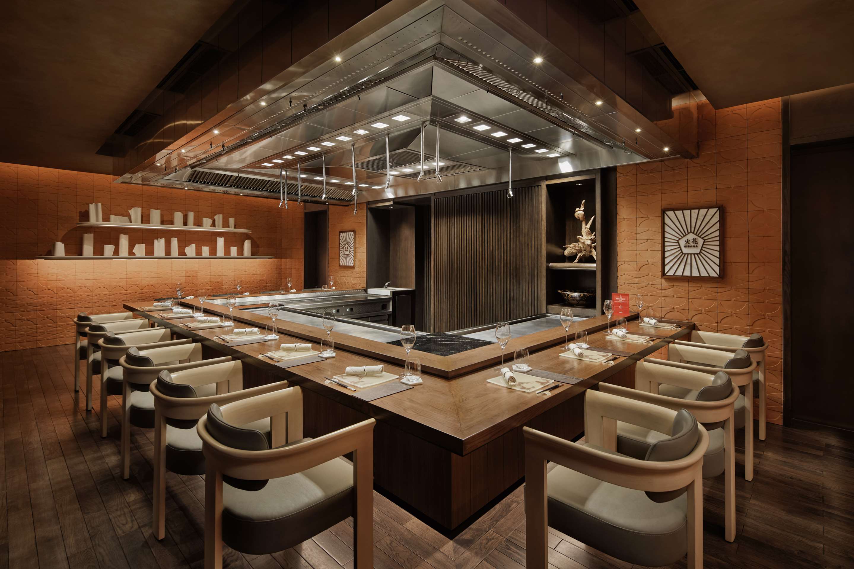 chairs around a teppanyaki grill dining experience in a wood restaurant