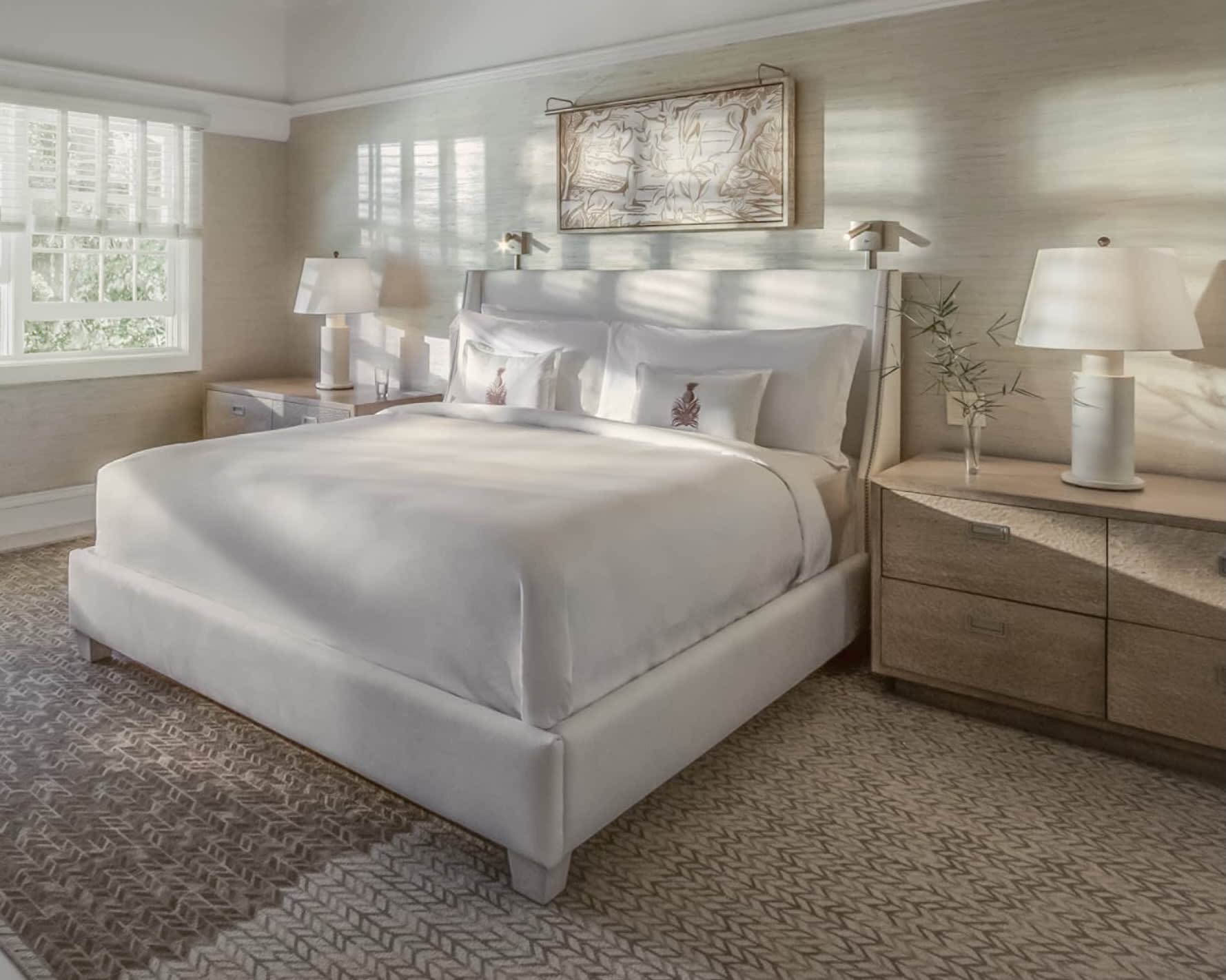 white bedroom with bed, headboard, lamps, and window with light