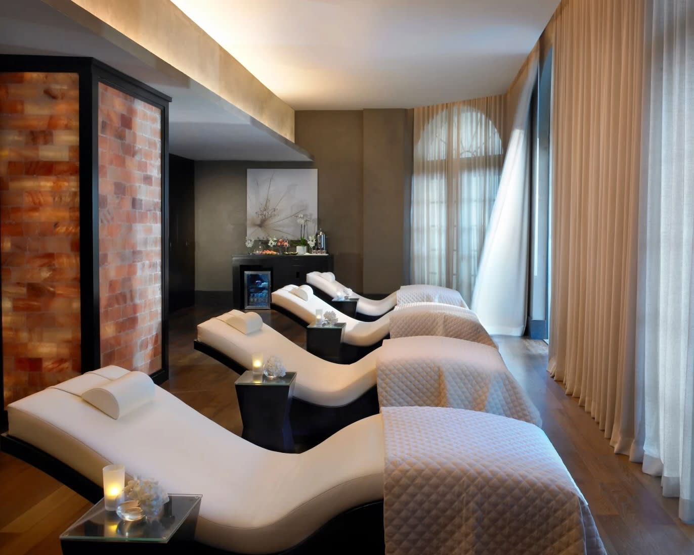 white lounge chairs facing white curtain covered windows in a spa relaxation room during day