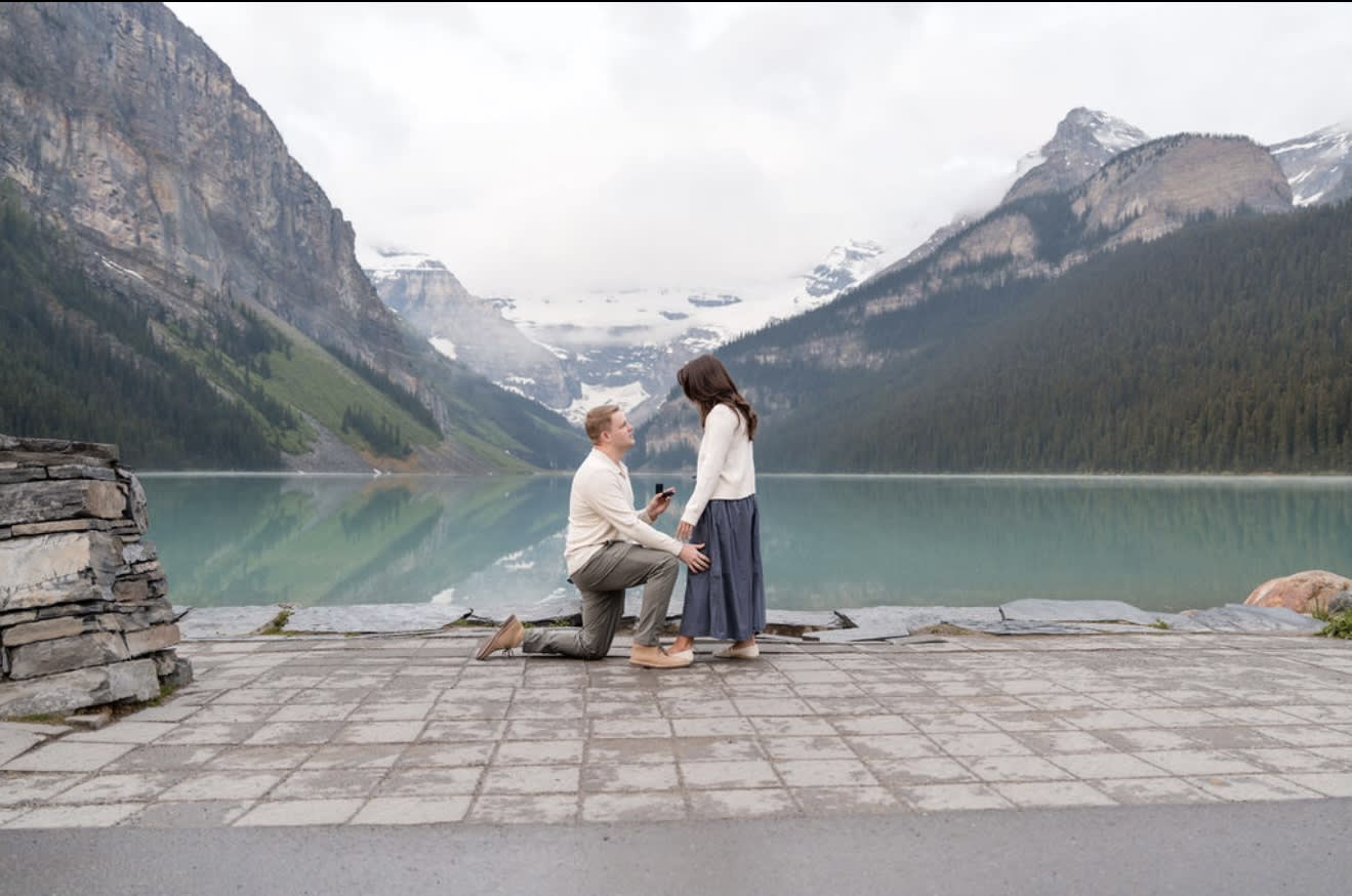 A couple gets engaged with Lake Louise in the background