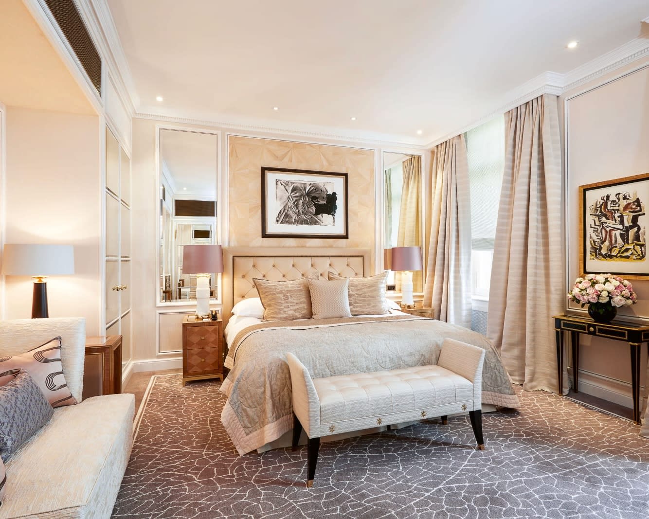 contemporary designed hotel room with bed, ottoman, and mirrors behind bed
