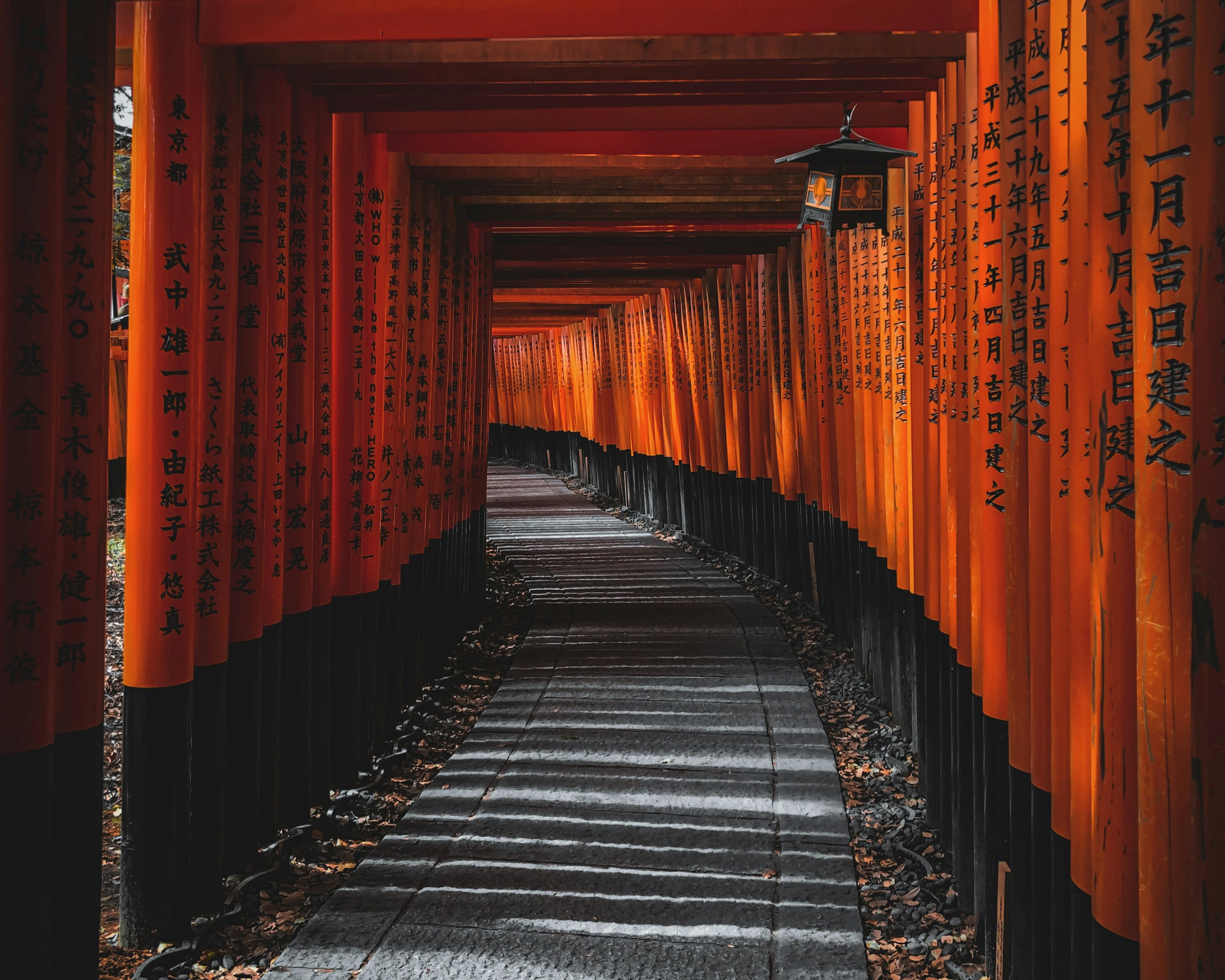 red temple shrine covered path with japanese characters