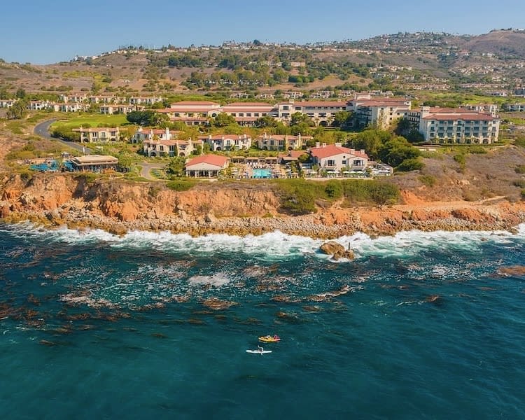 a luxury resort on top of cliffs overlooking turquoise ocean
