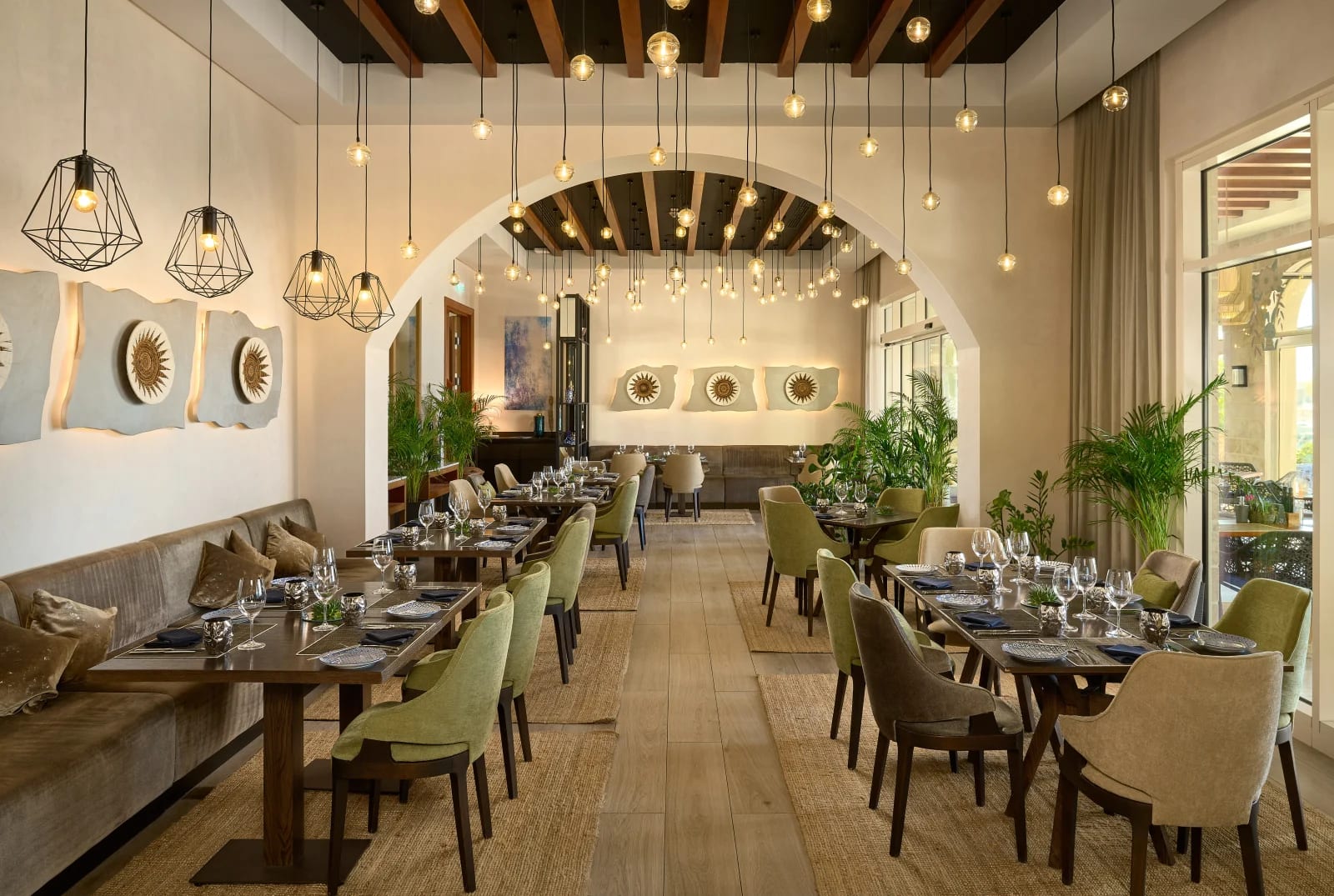 olive green chairs and brown bench seats with overhead lights in a modern restaurant setting