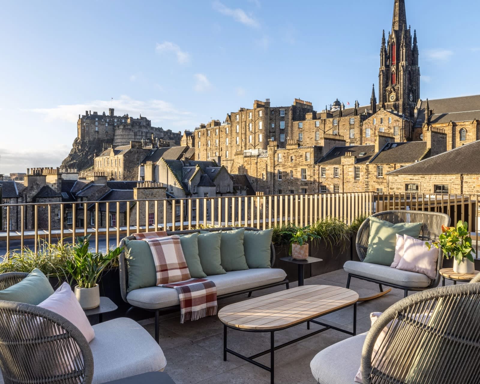 rooftop lounge seating with castle, tower, and city skyline behind