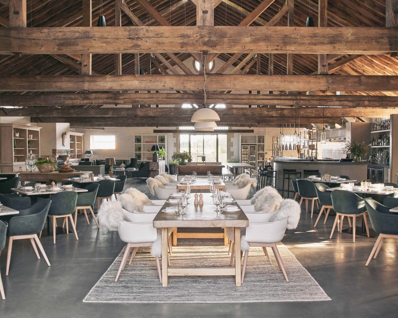 wood beam ceiling over a restaurant with white and dark grey chairs