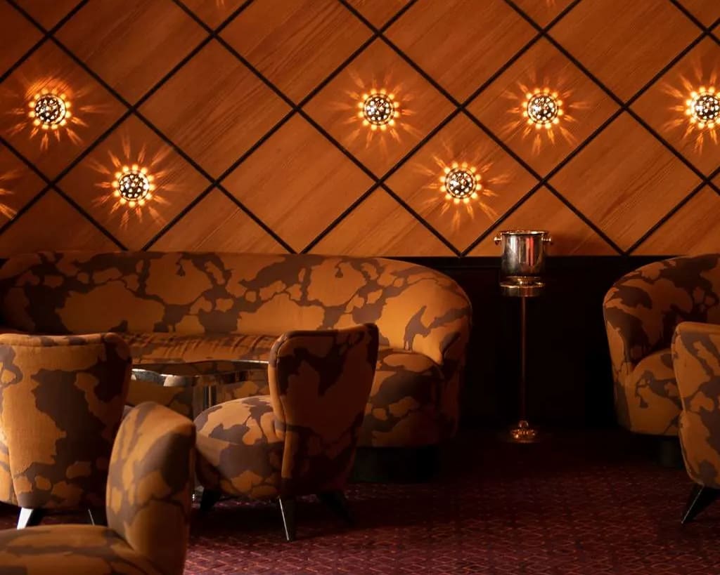 cozy brown lobby lounge with maroon carpets, tan fabric seats, and brown wood walls