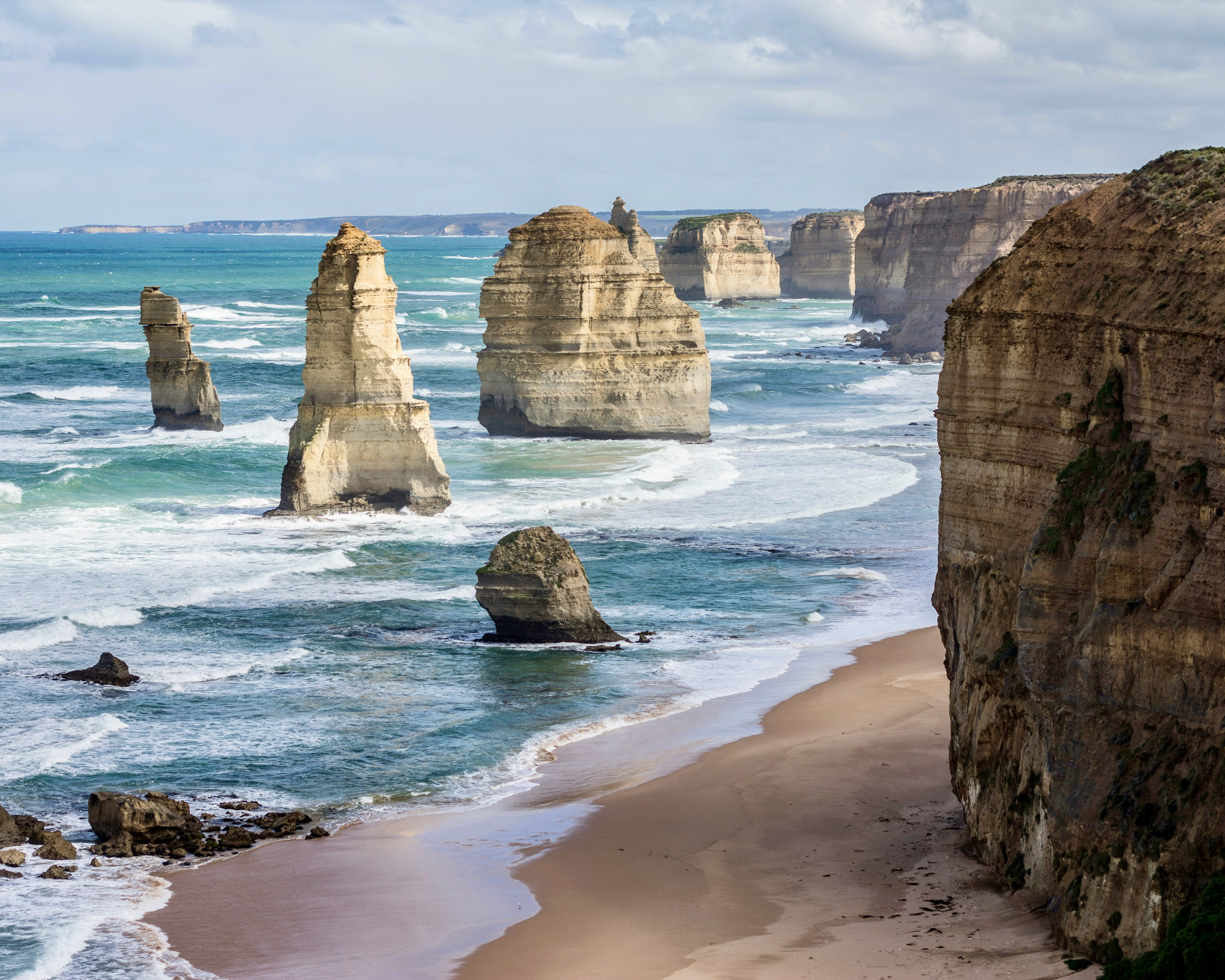 tall white stone rocks rising out of the ocean just offshore