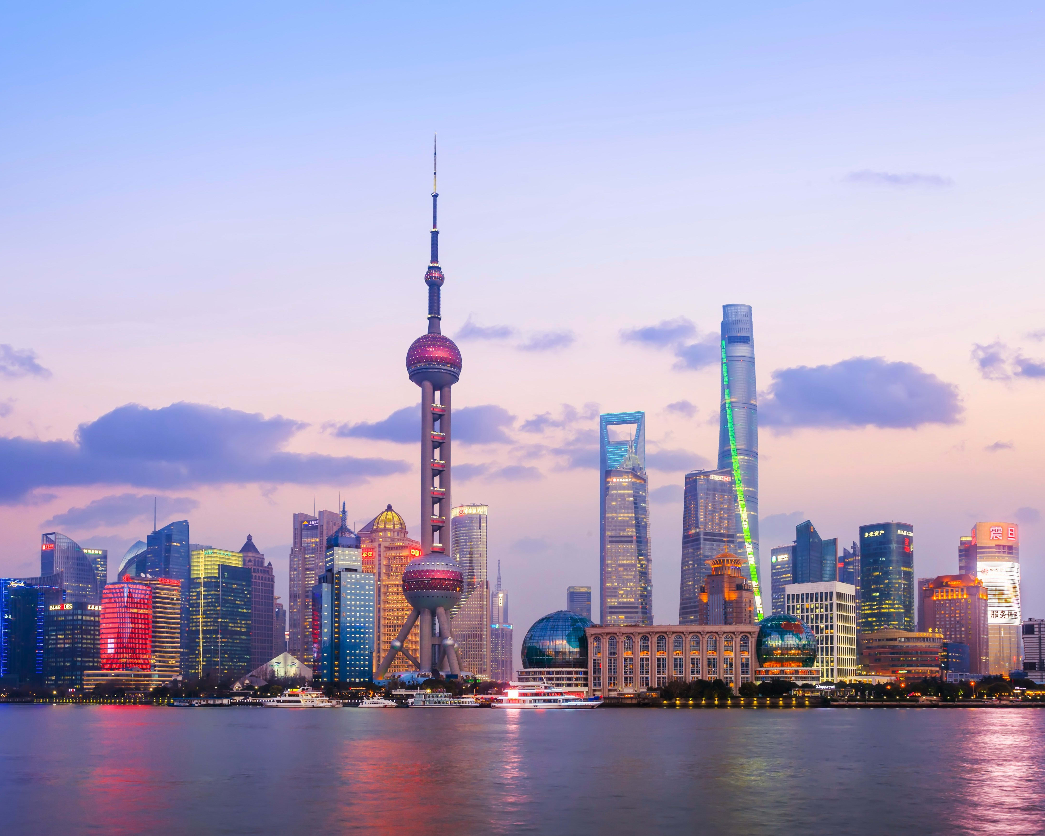 modern waterfront city with tall skyscrapers and neon lights at dusk