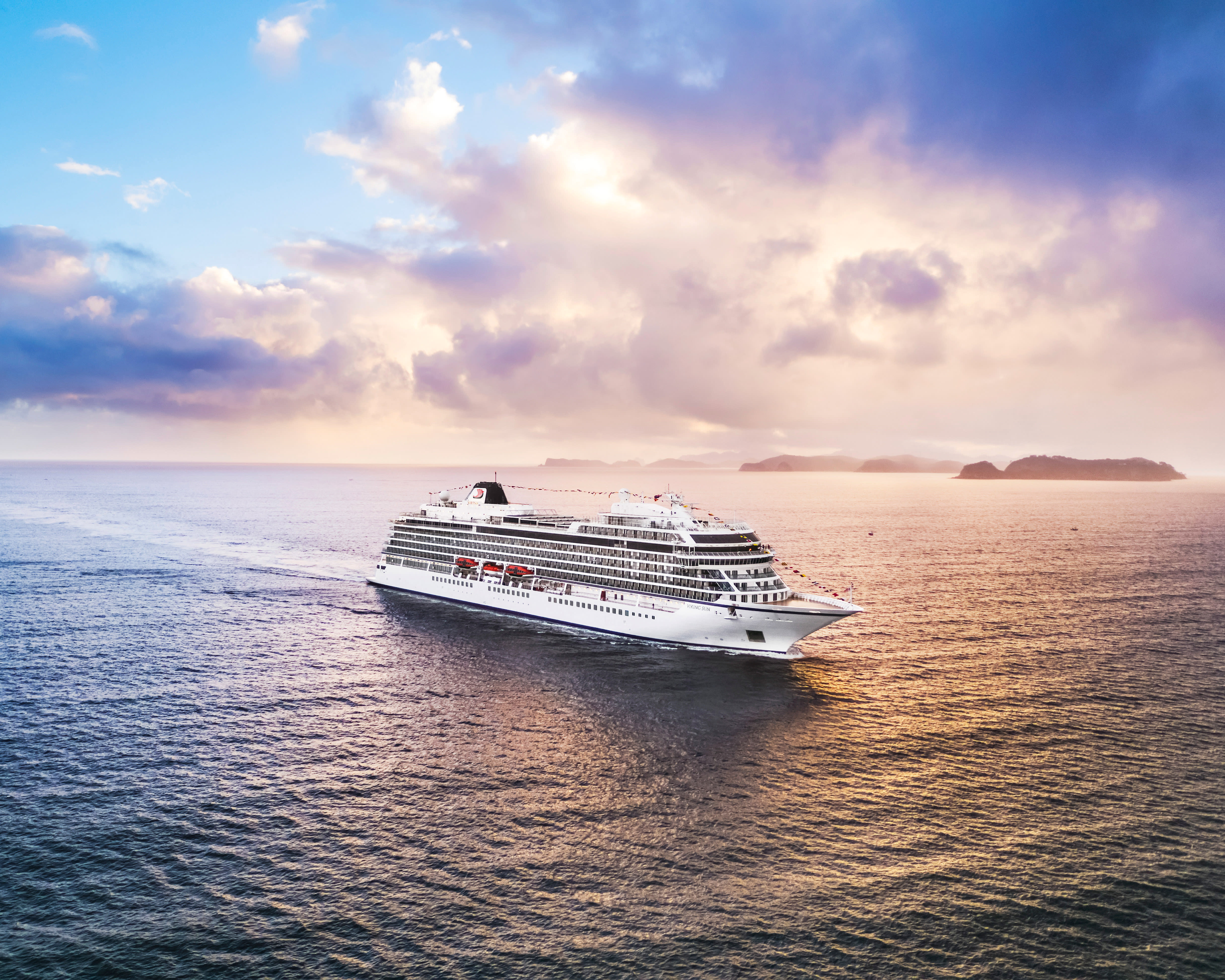 a modern luxury white cruise ship at sea during sunset
