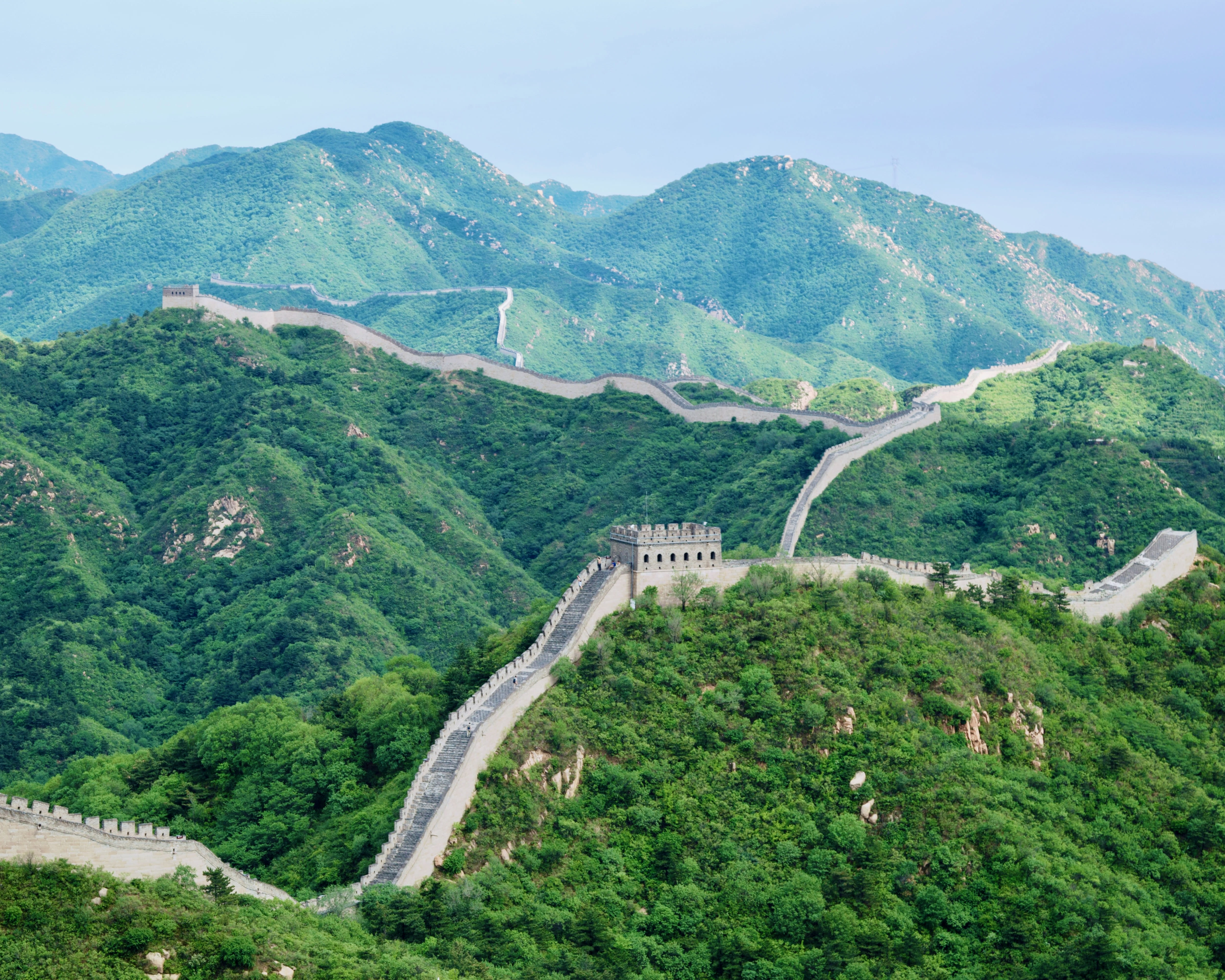 grey stone walls snaking across green forested mountain tops