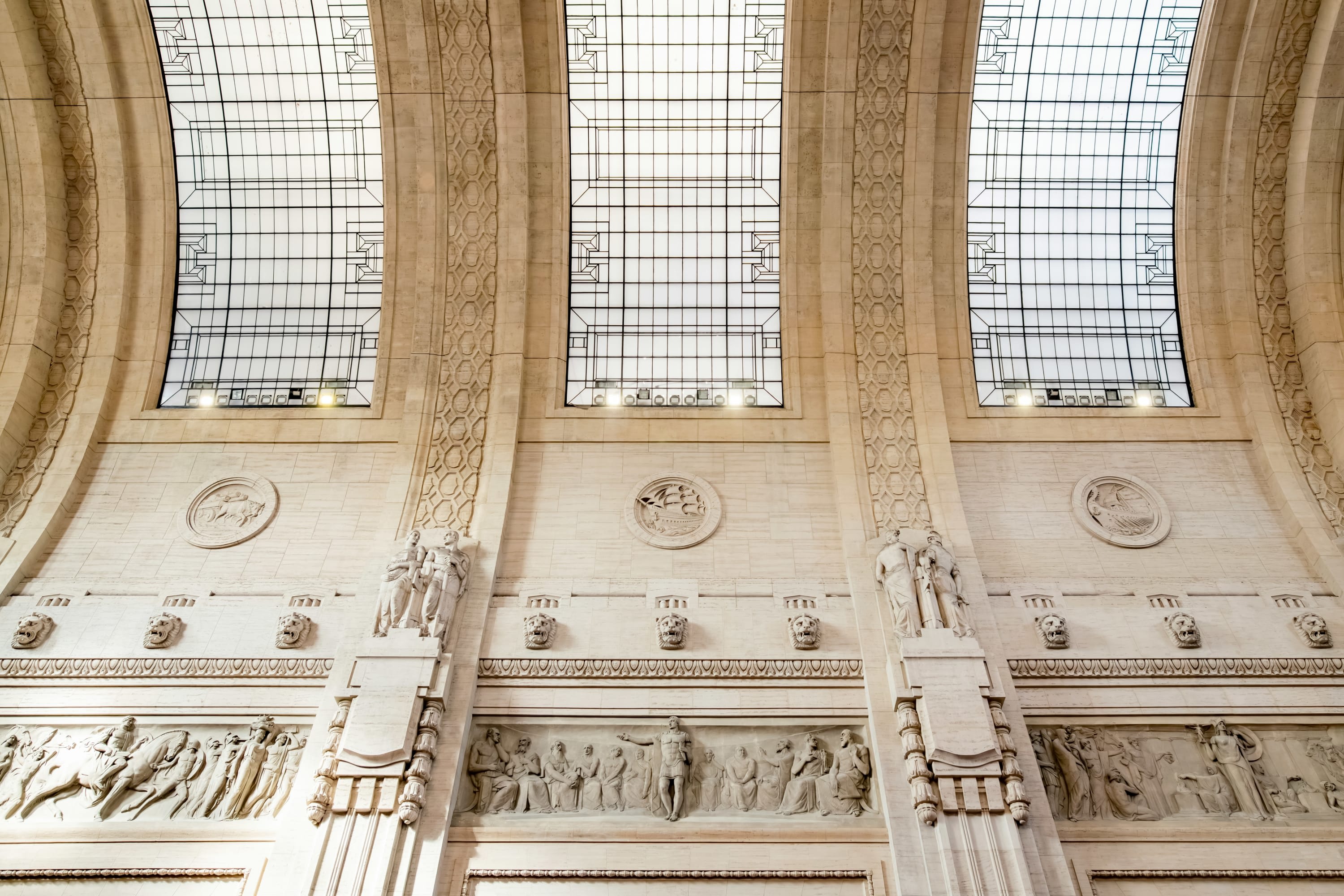 Ornate carvings and glass skylights in the stone ceiling of Milan's Central Station