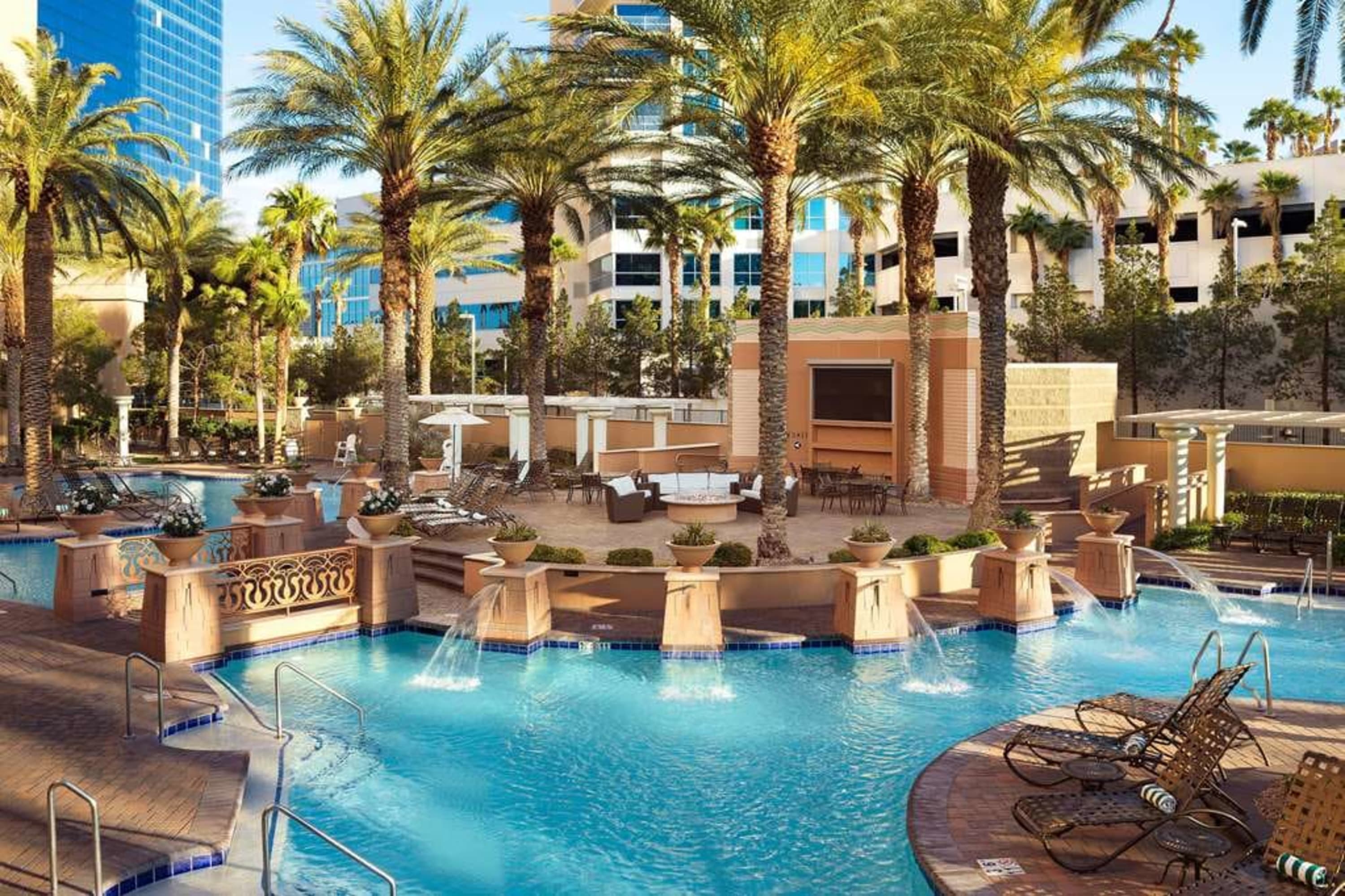 Palm tree-laden pool area with Mediterranean design influences and lots of water features