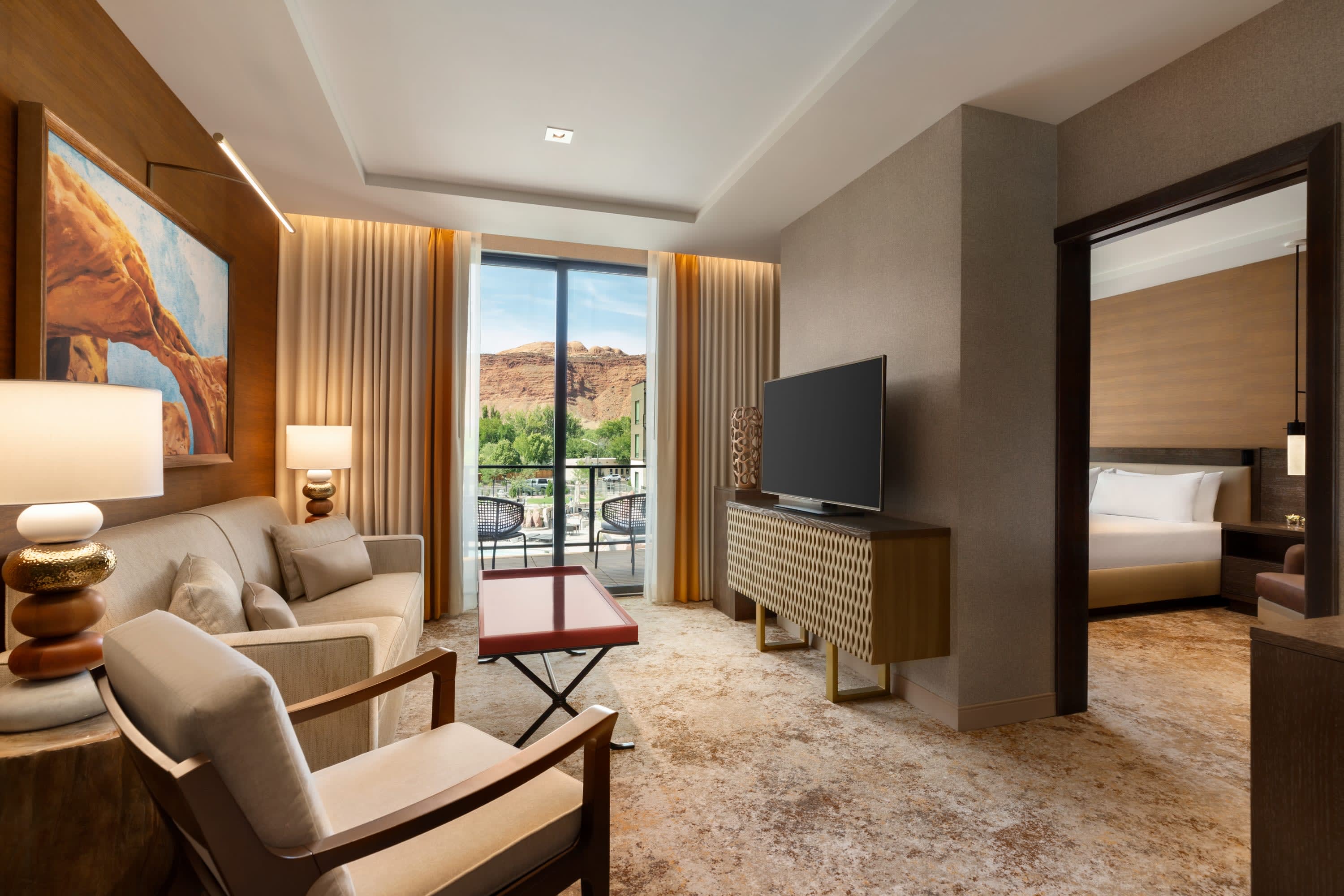 Nice, simple furnishings in a desert color-palette room with a view of Moab through sliding glass doors