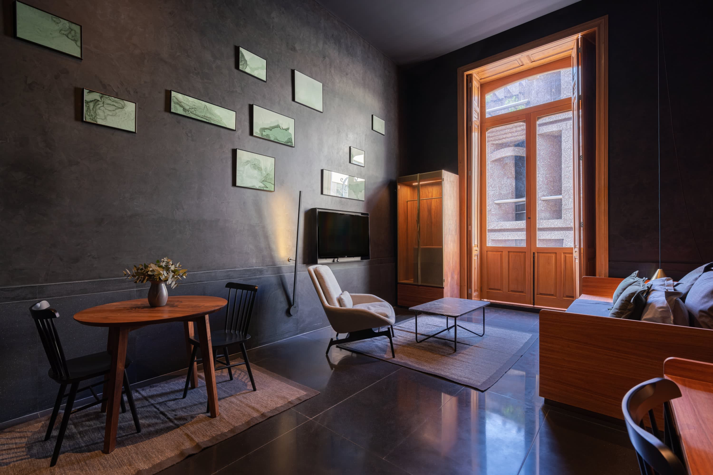 Sleek, contemporary decor with a black and natural wood color palette in a spacious hotel room
