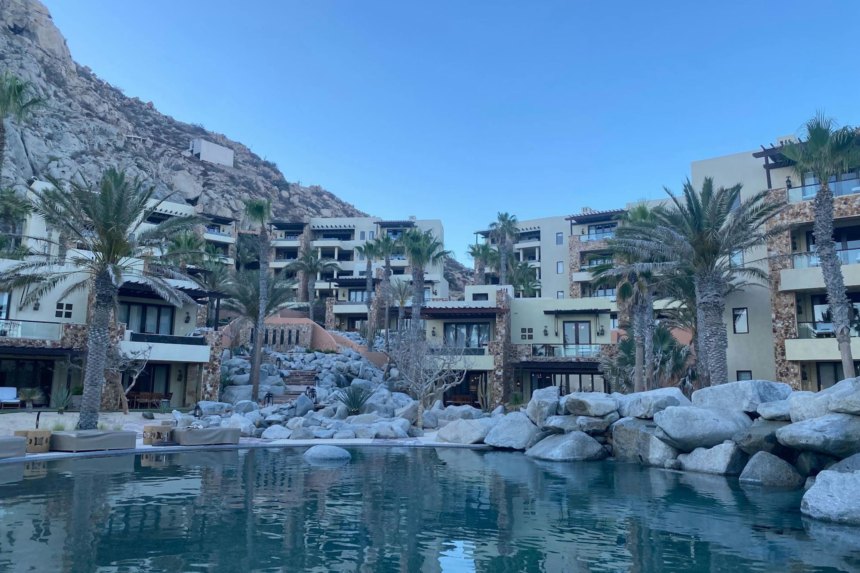 A large pool mimics a natural lagoon with contemporary, adobe-esque architecture in the background