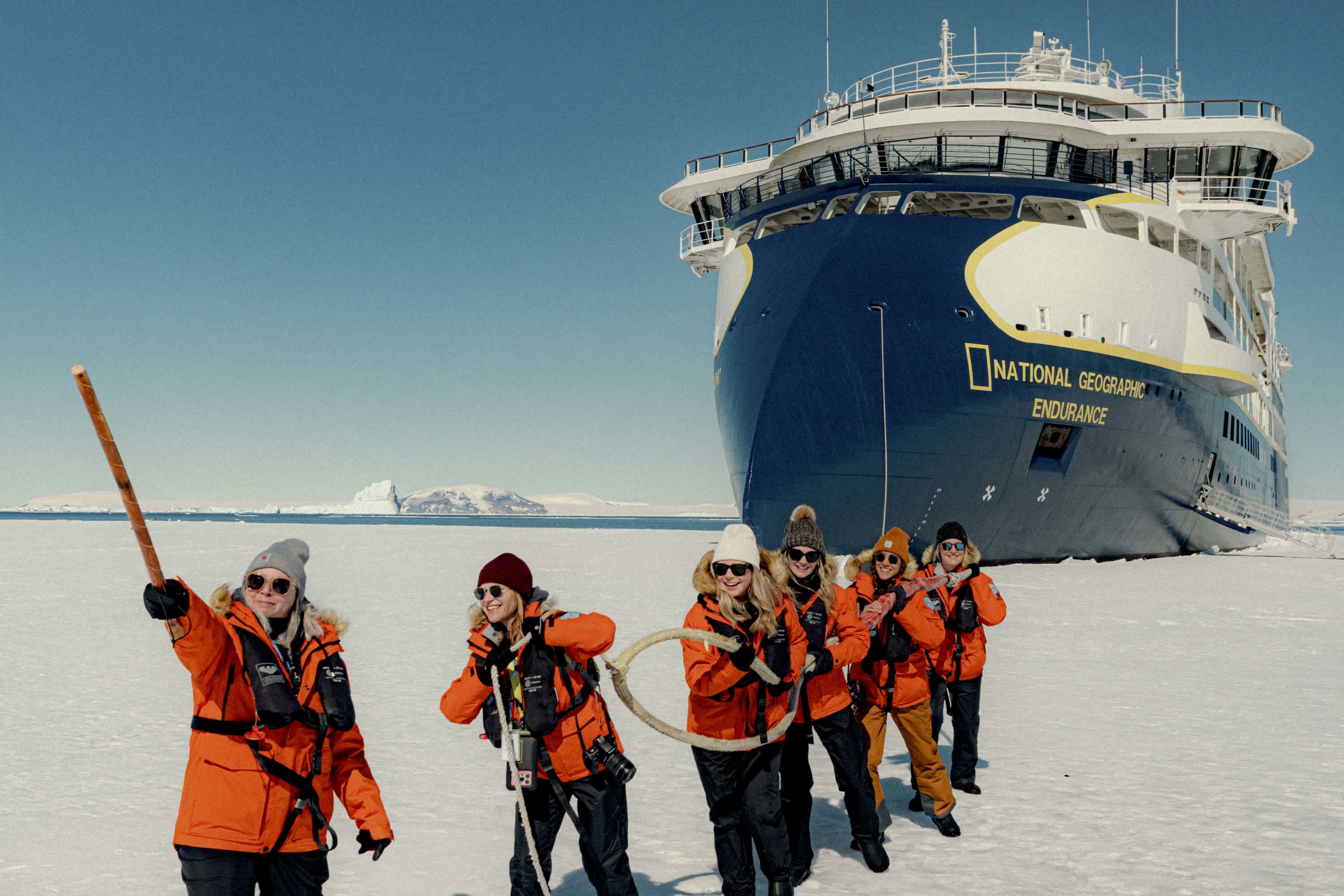 A few Fora Advisors and crewmembers pose faux-gallantly for the camera in front of a National Geographic icebreaker ship