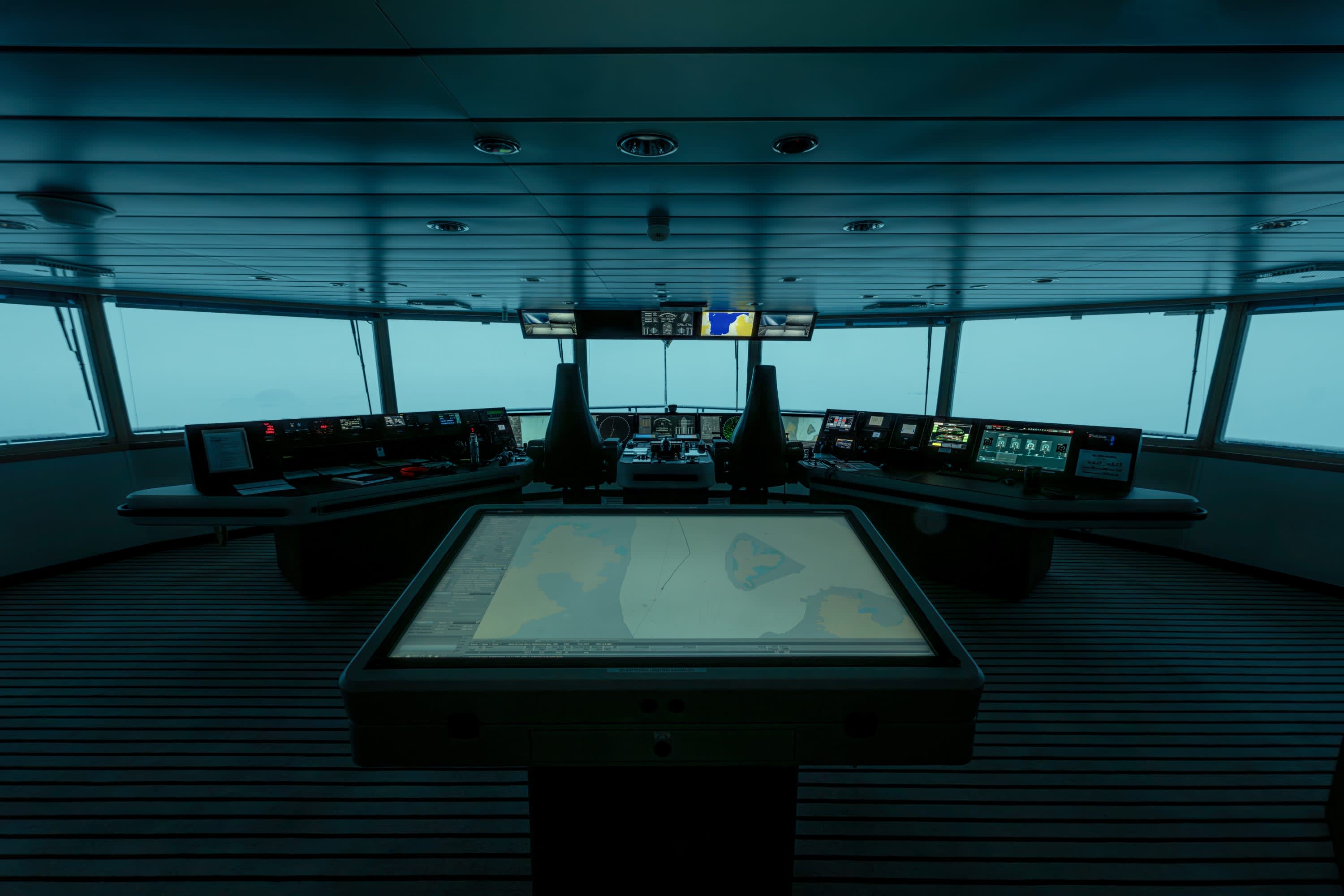 Various technical readouts, control terminals and a large touchscreen map in a command center