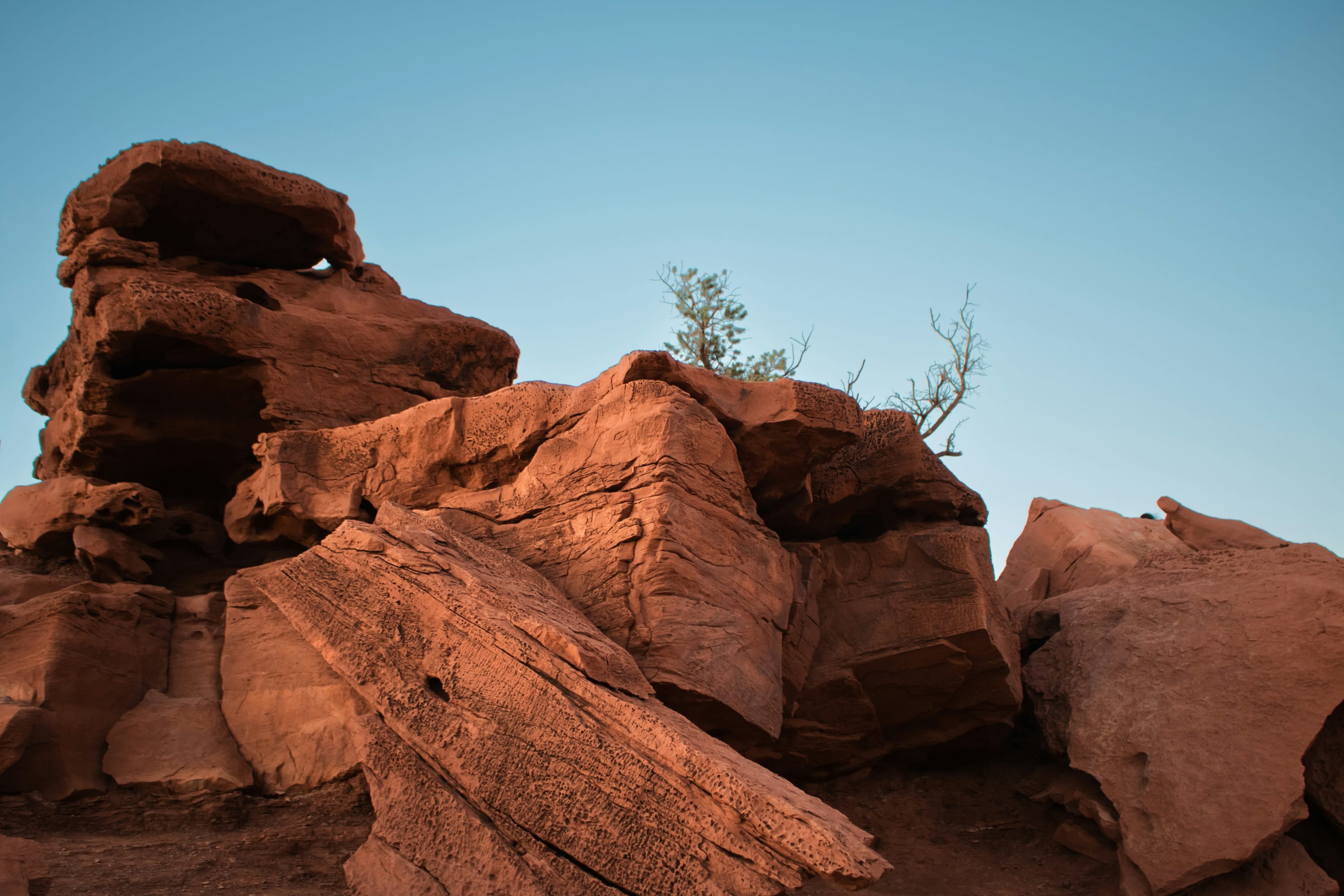 Red rocks rising up in an unusual formation with faint brush rising up behind