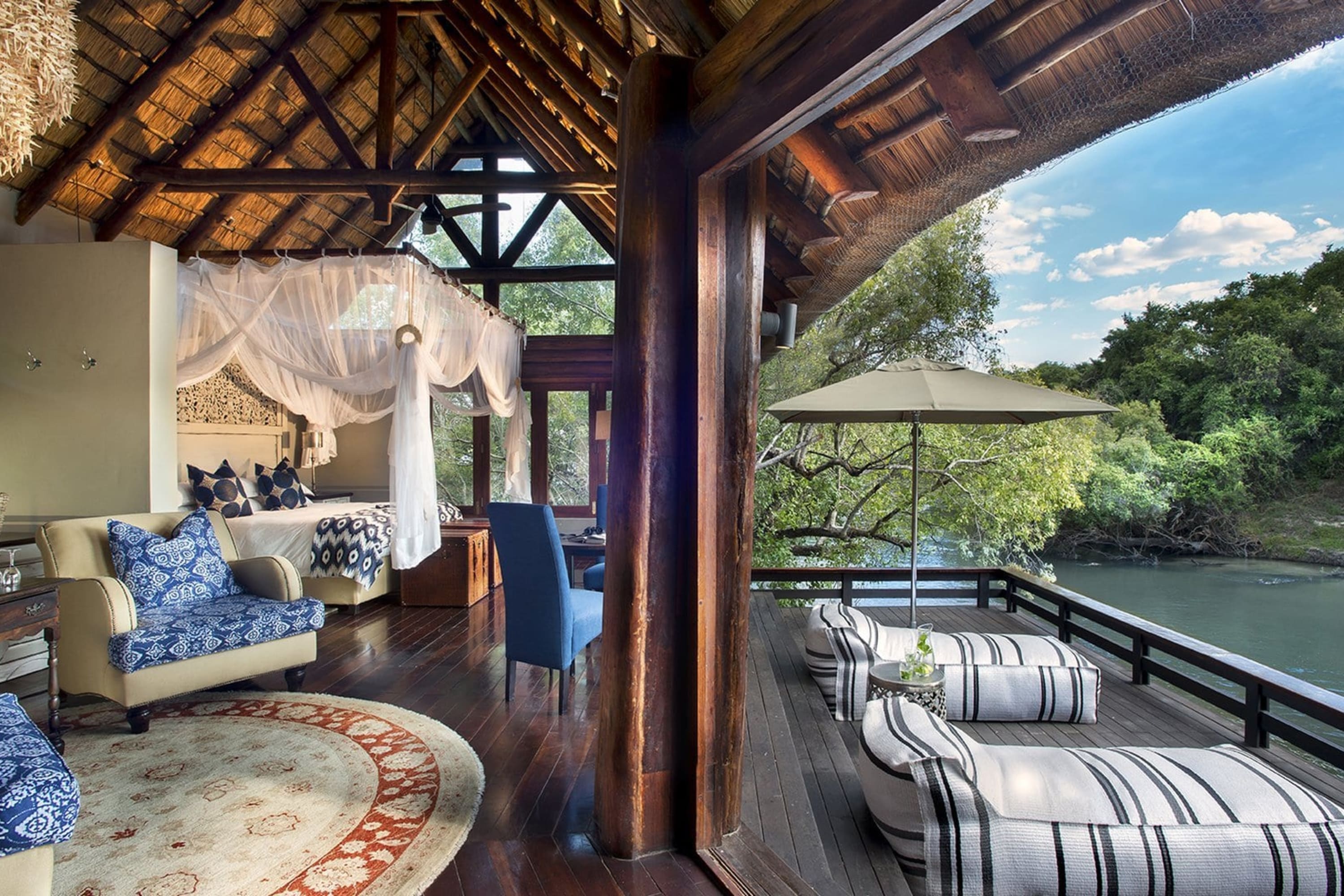 Luxurious room with lots of hardwood features, locally inspired fabrics and lounge chairs looking out over the river