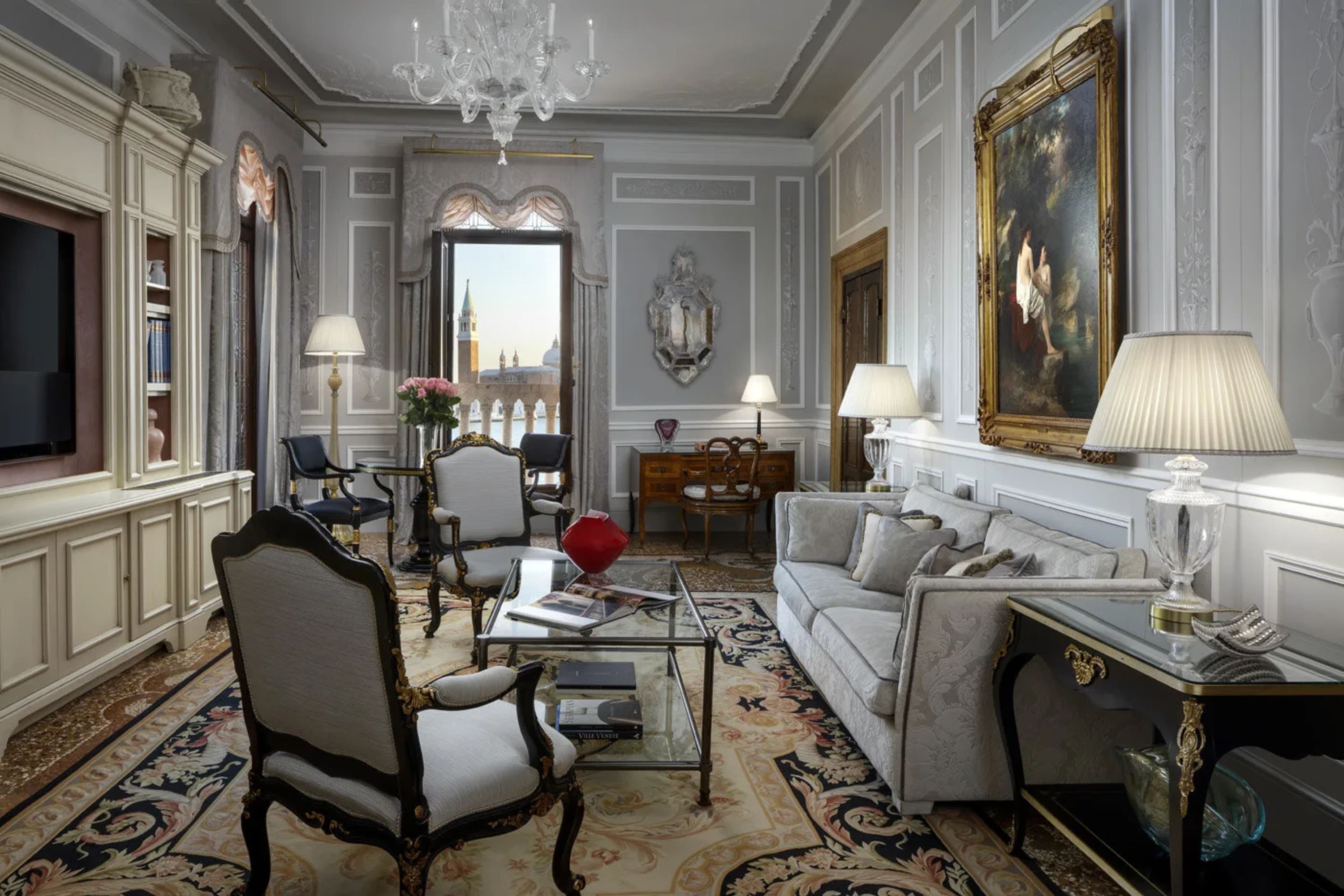 Exceptionally elegant Old World-style furnishings with an open window in the background revealing historic Venice landmarks