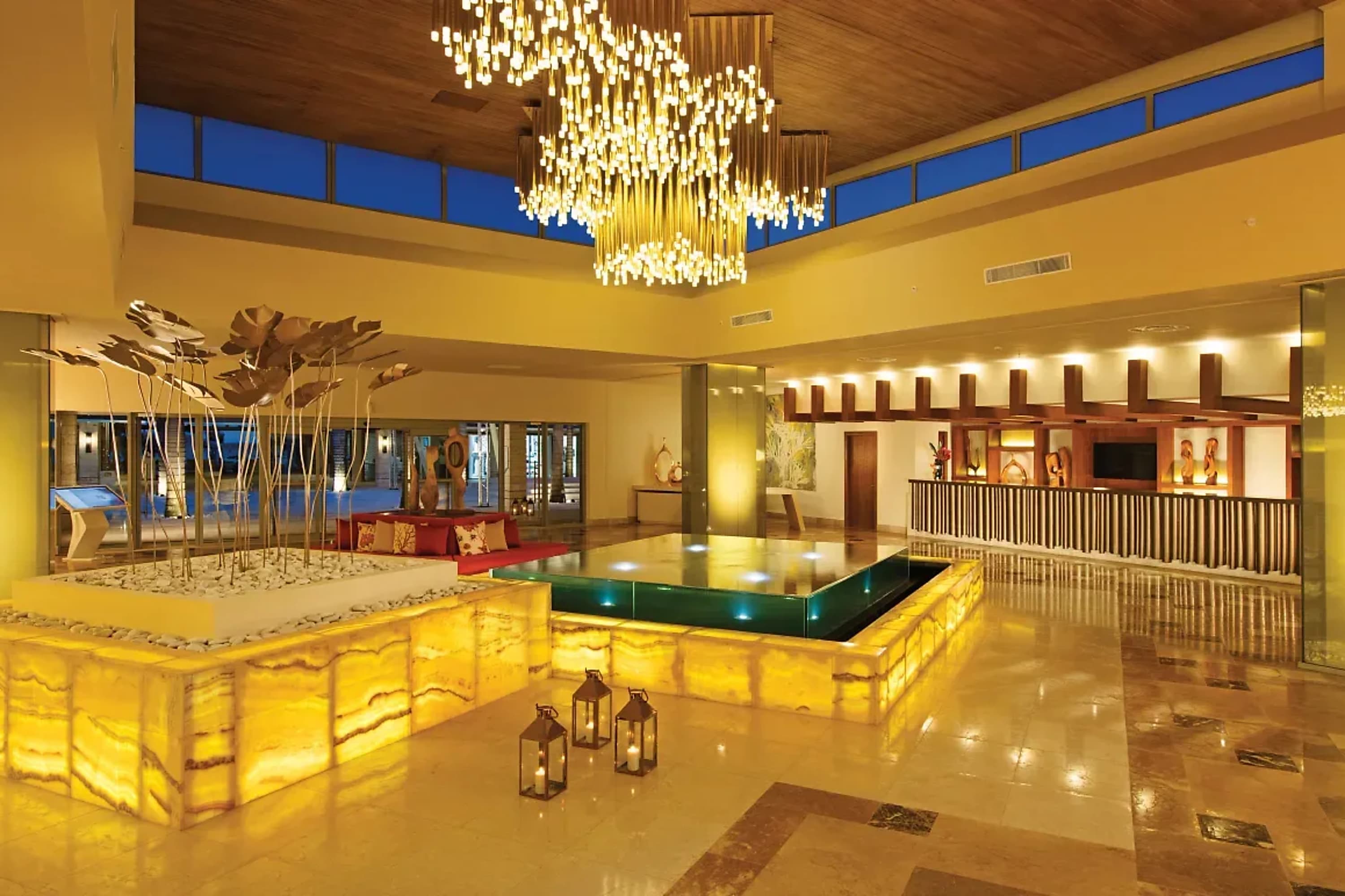 A luxe lobby with elegant accents, a geometric water feature and a crystal chandelier