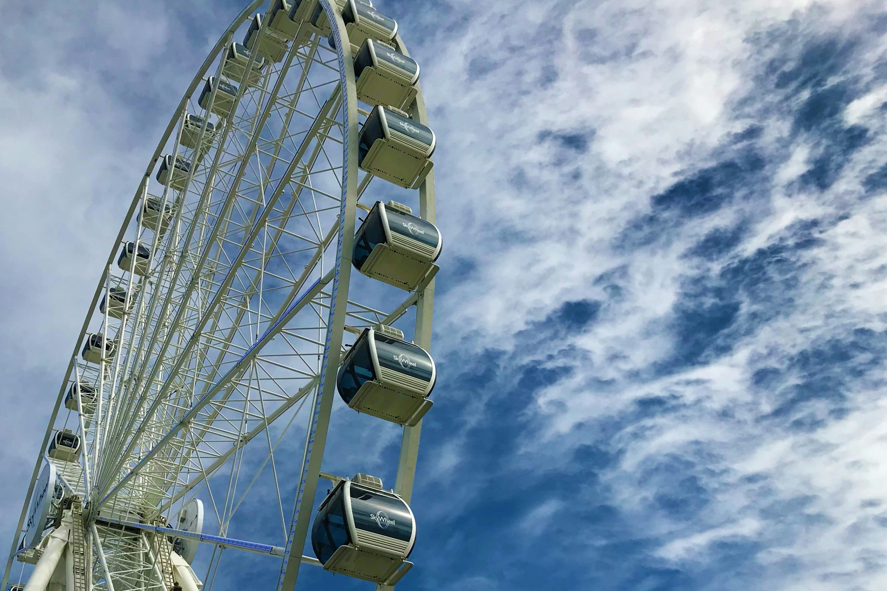 Ground view of the Myrtle Beach Sky Wheel with partly cloudy but blue skies