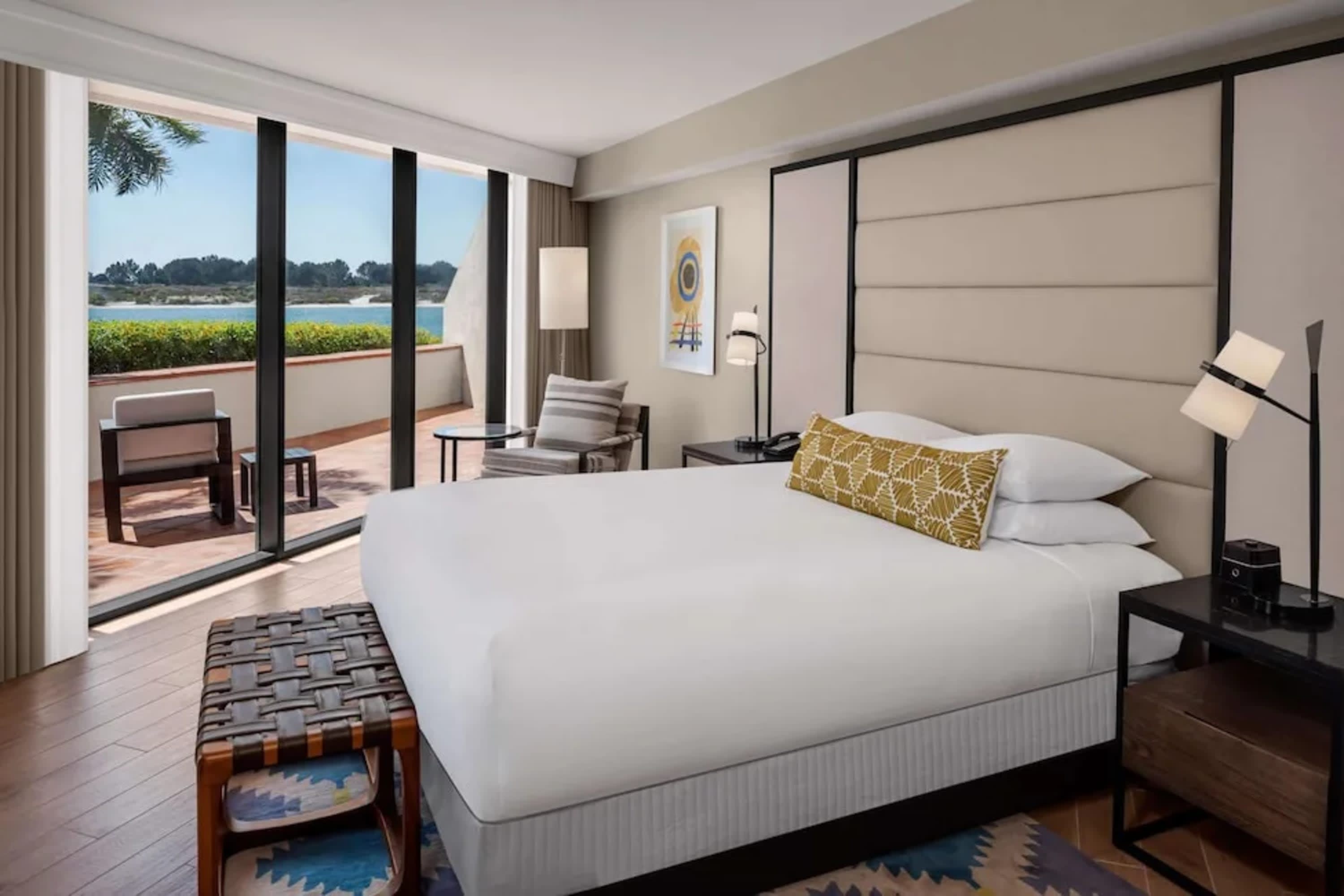 Spacious room with pops of color and large windows showing the bay