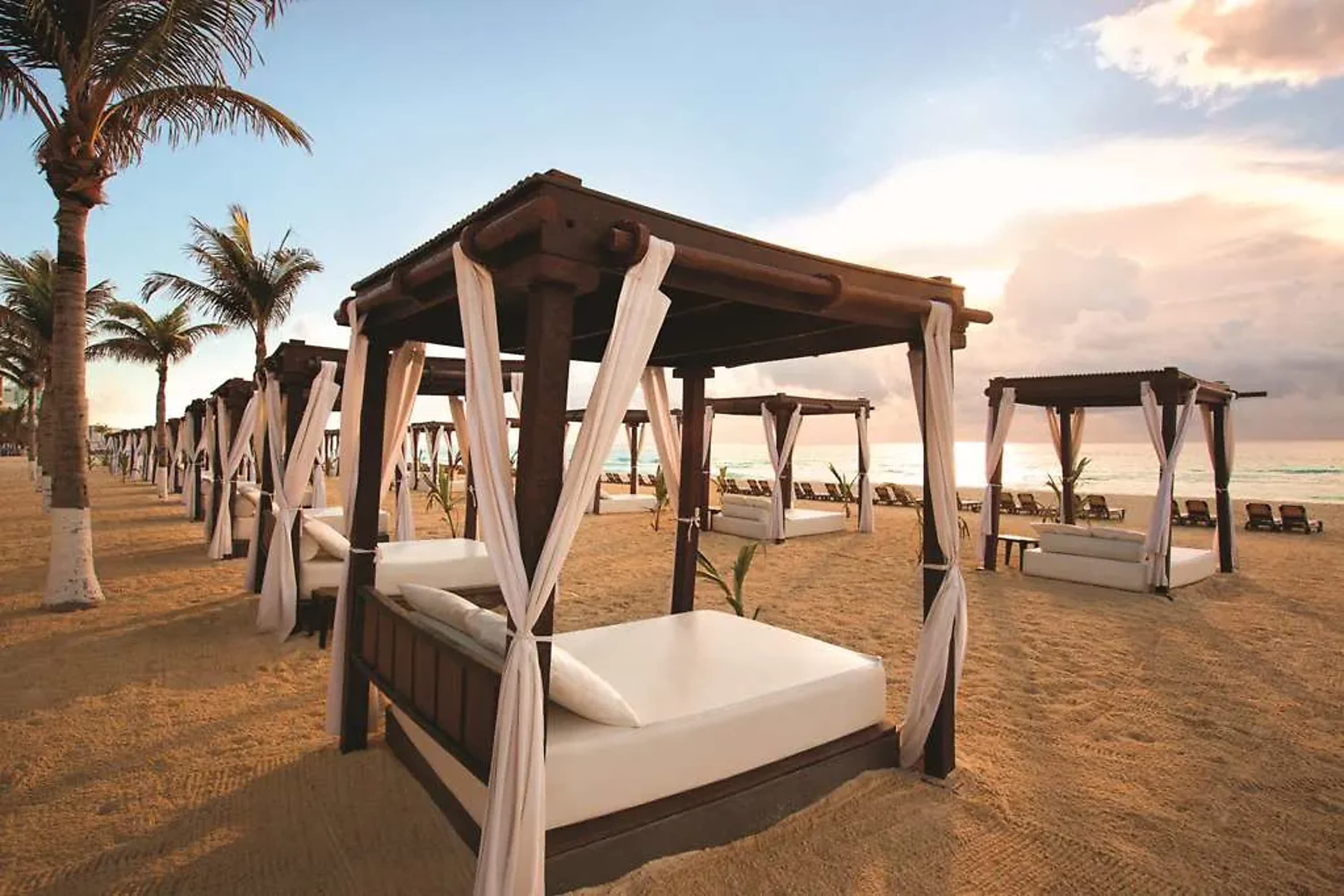 A series of day beds with closable drapes directly on gold sands at the beach