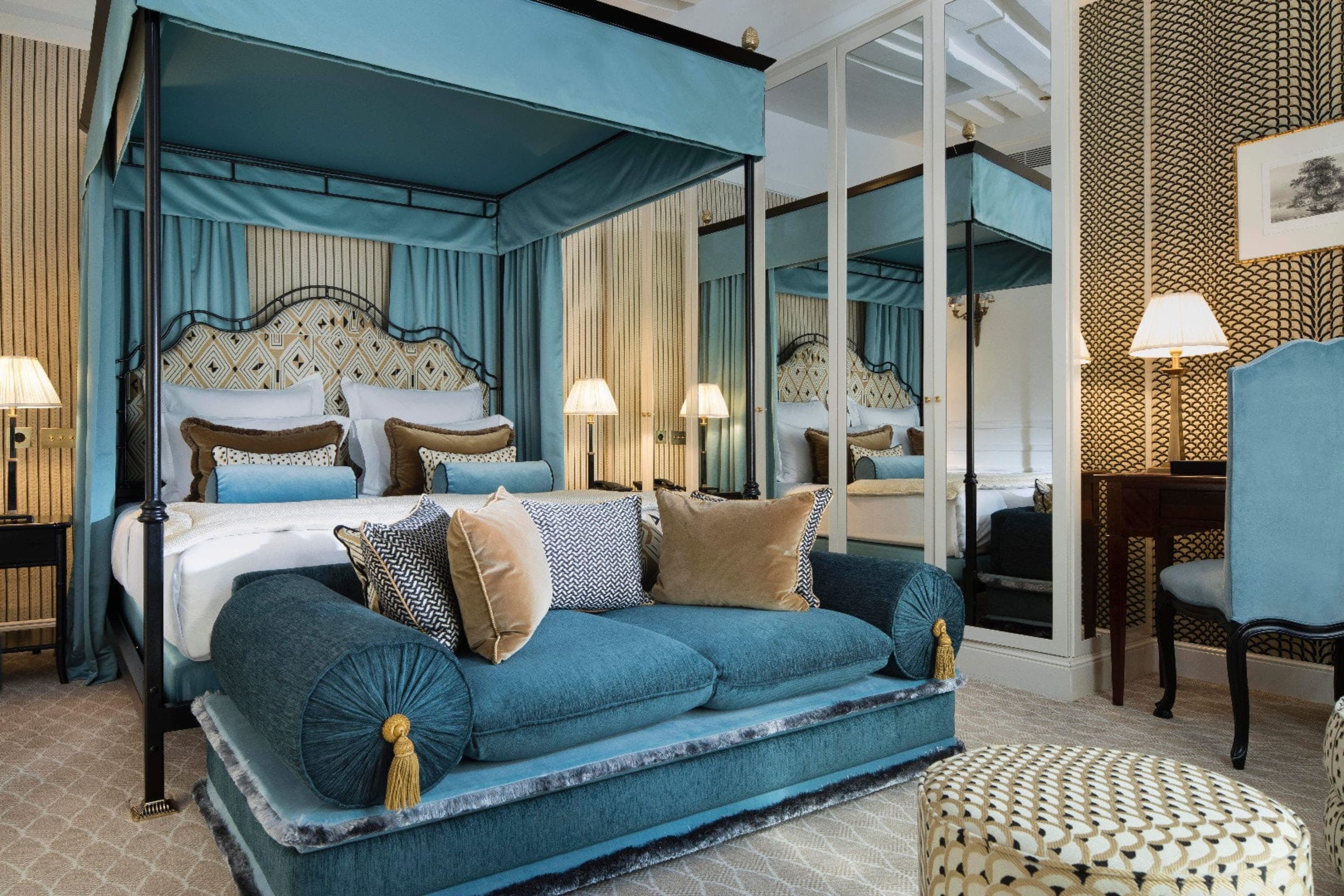 Elegant hotel room with bold deep-blue fabrics and stylish Art Deco-esque furnishings
