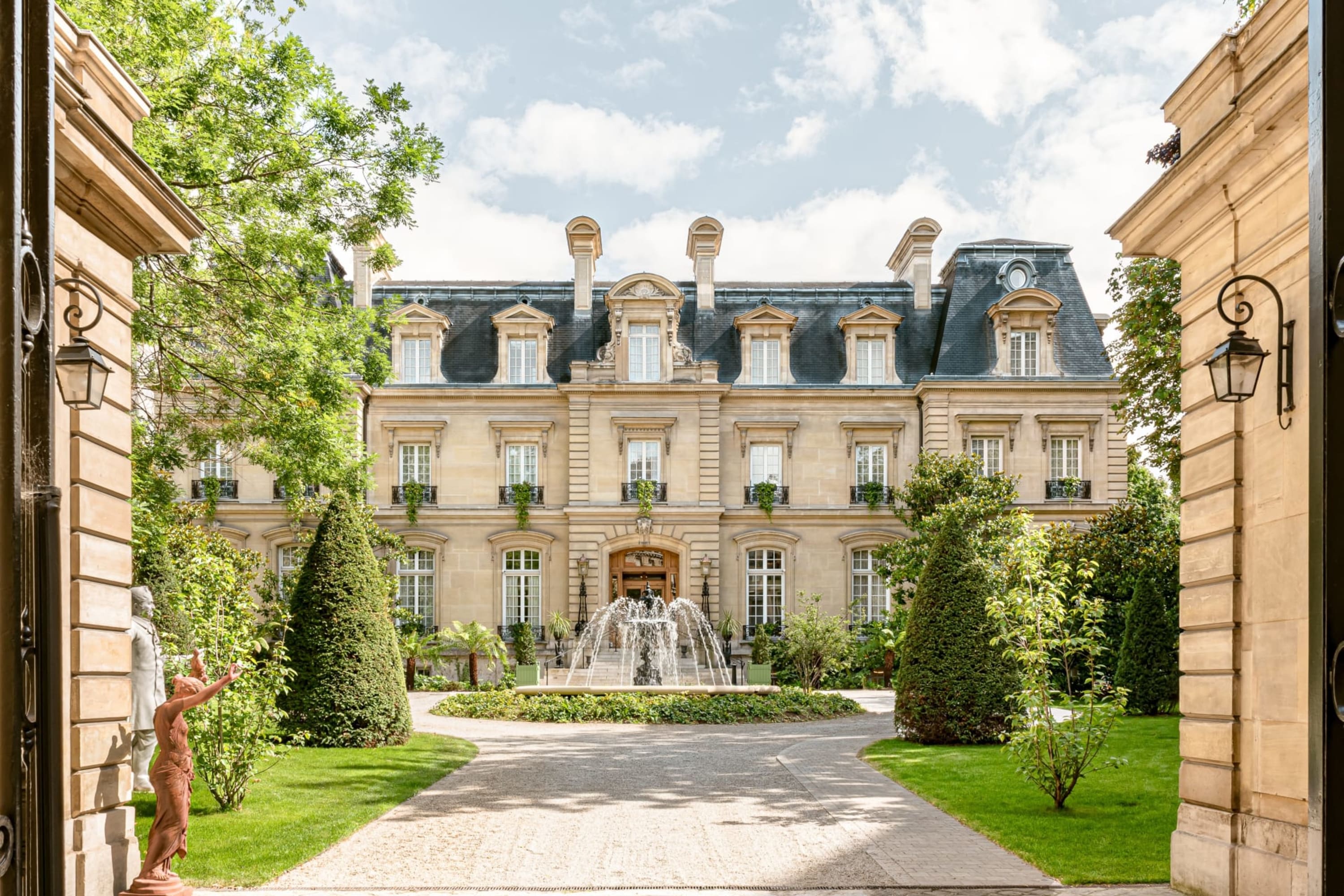 Grandiose courtyard entrance with the historic facade of the property featuring prominently behind a water fountain