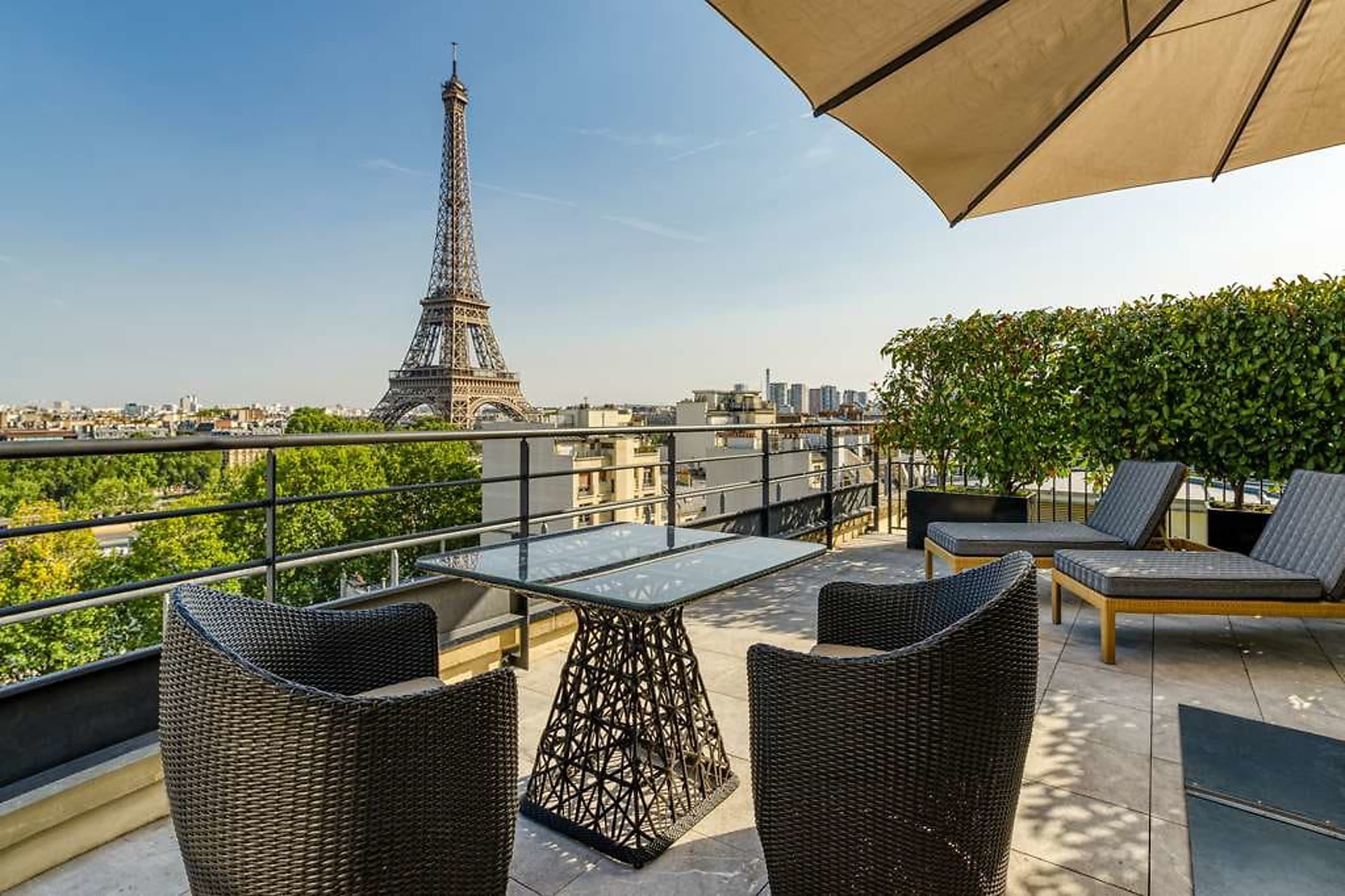 Chic terrace area with table settings and an incredible view of the Eiffel Tower, likely less than half a mile away