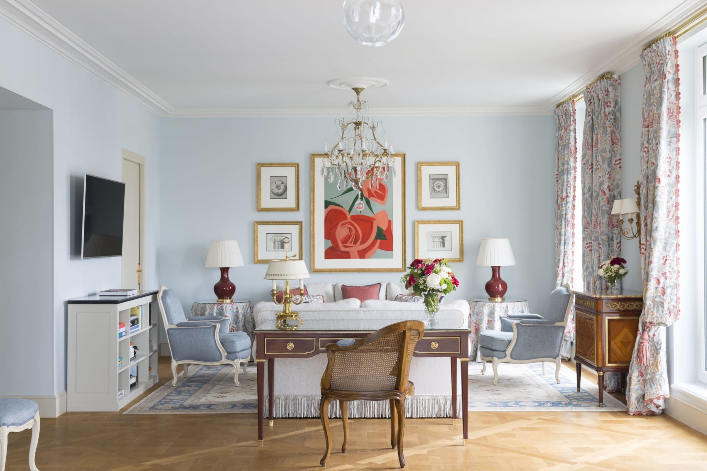 A room with soft-blue walls, chic and trendy decor, a sense of being lived in but clean and eclectic but interesting art