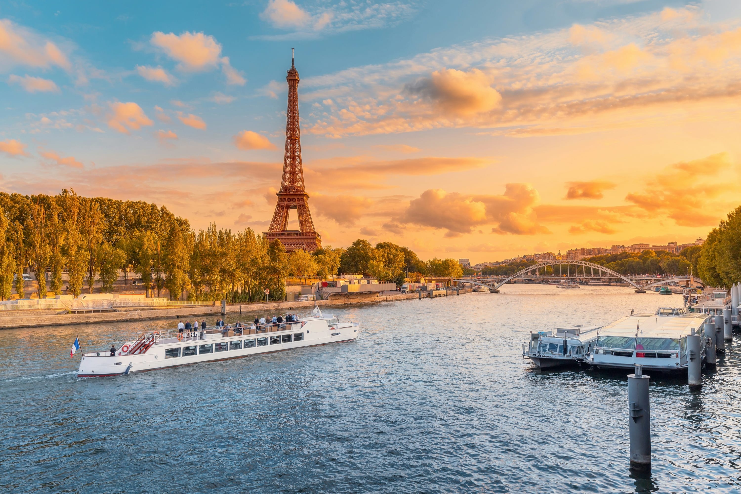 At sunset: a Batobus river boat cruises along the Seine with the Eiffel Tower in the background