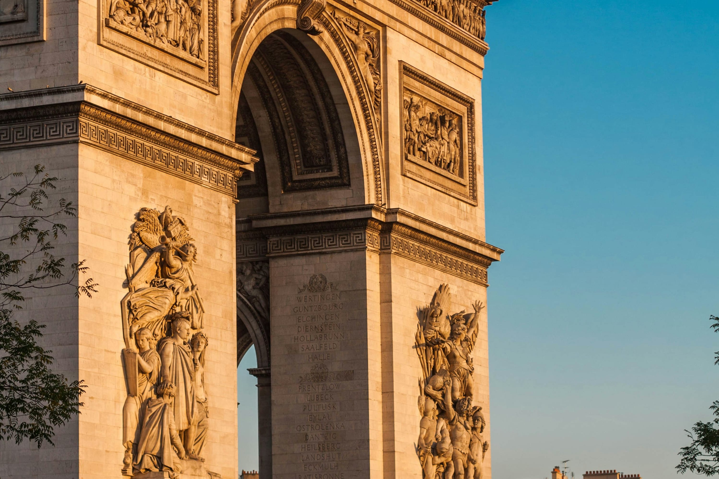 A closeup reveals sculpture details in the Arc de Triomphe's twin columns and arch