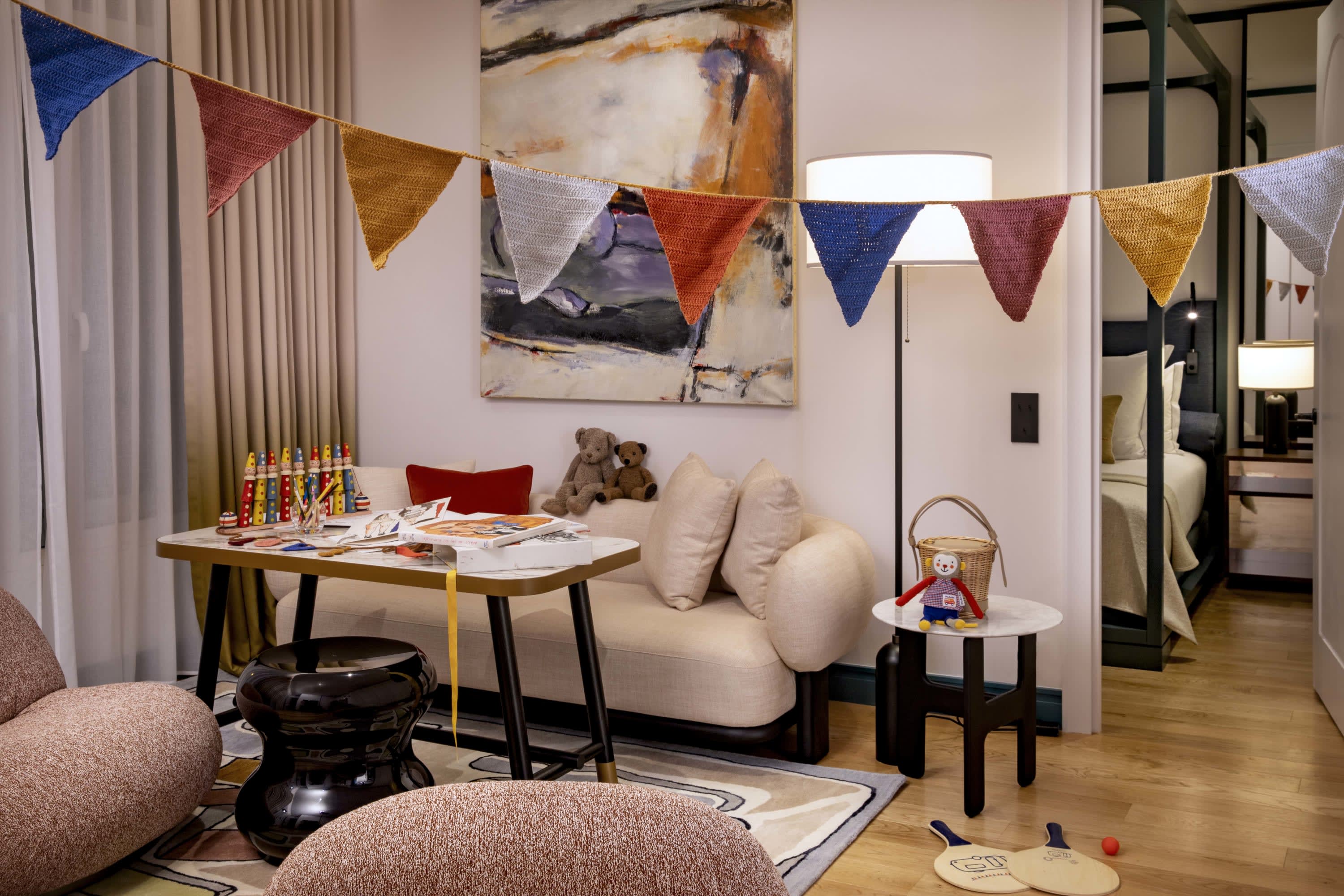 Child-friendly but tasteful decorations fill a stylish and charming suite living room with a hallway to the right offering a sneak peak of a cozy bedroom