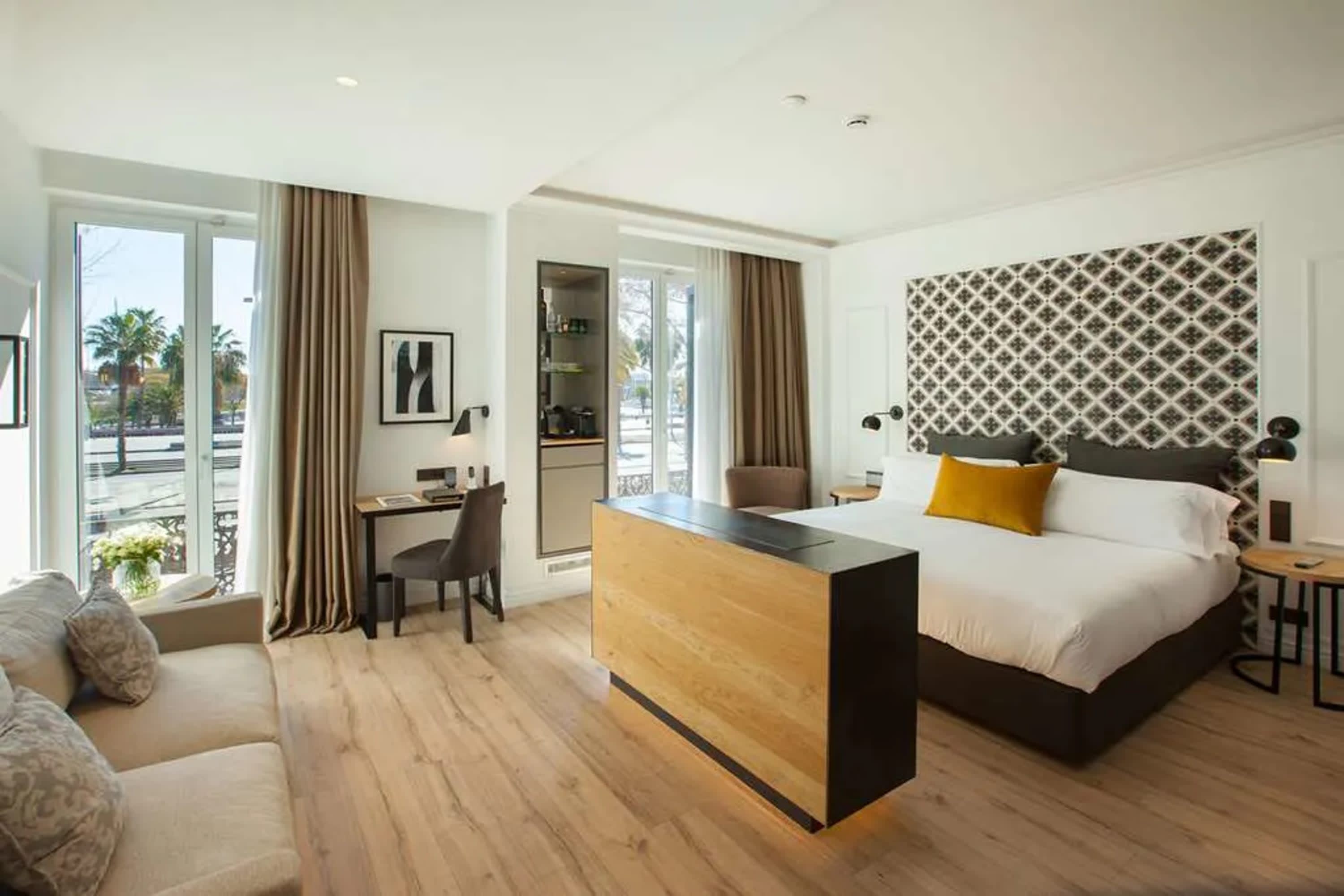 Stylish, huge hotel room with lots of natural wood and tones. The space is bright and refined, with chic decor.