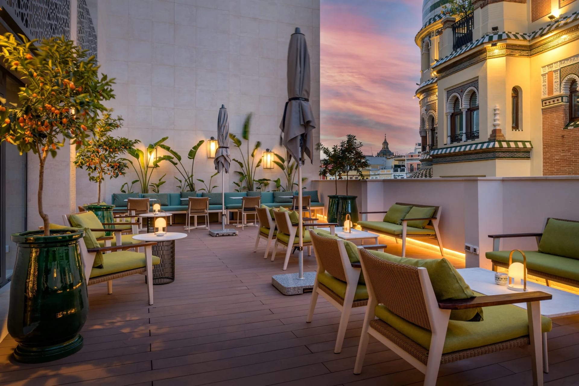 A chic terrace space with comfortable looking furniture across the street from a historical building