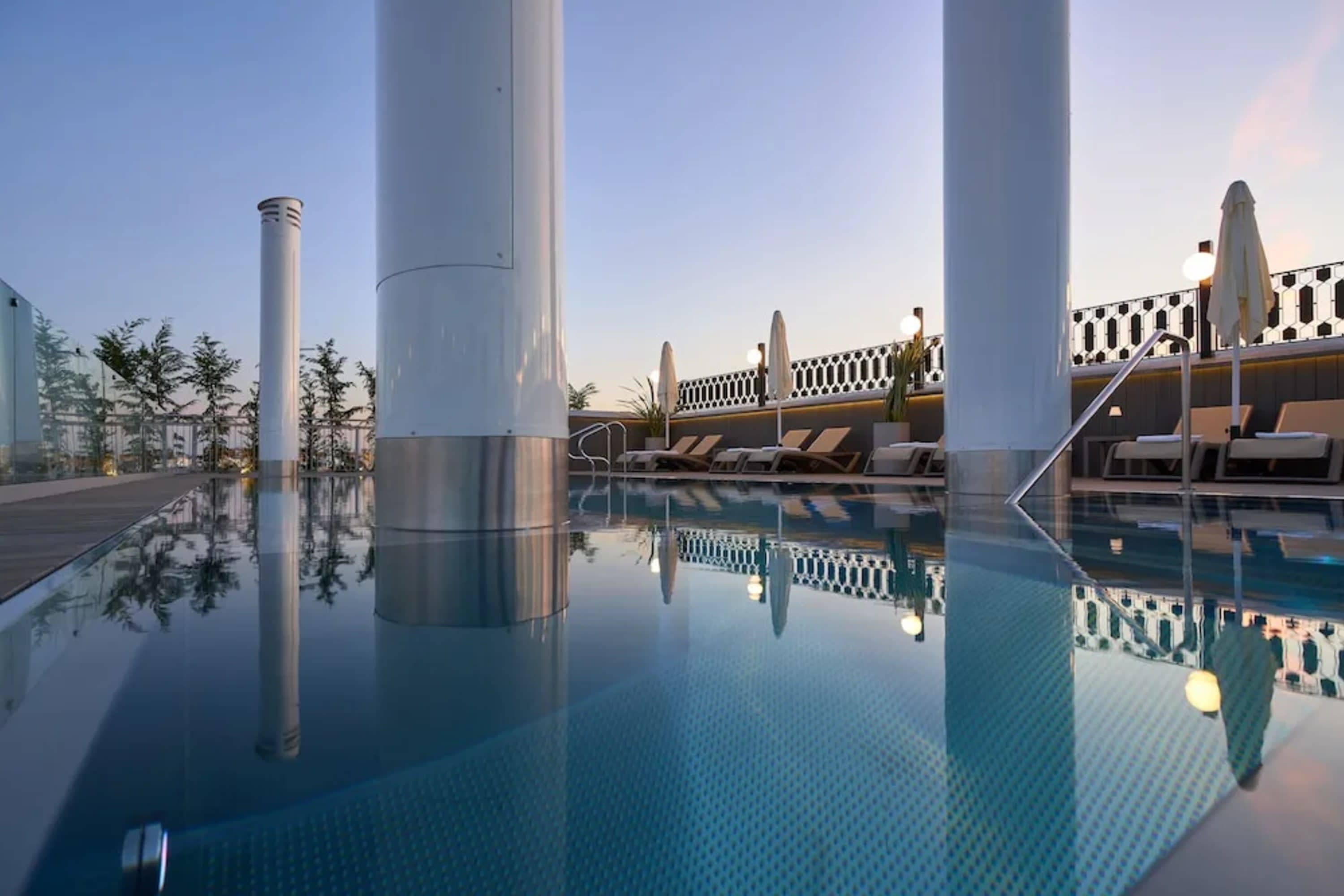 Chic rooftop pool area with smokestacks rising up out of the pool like an old cruise liner